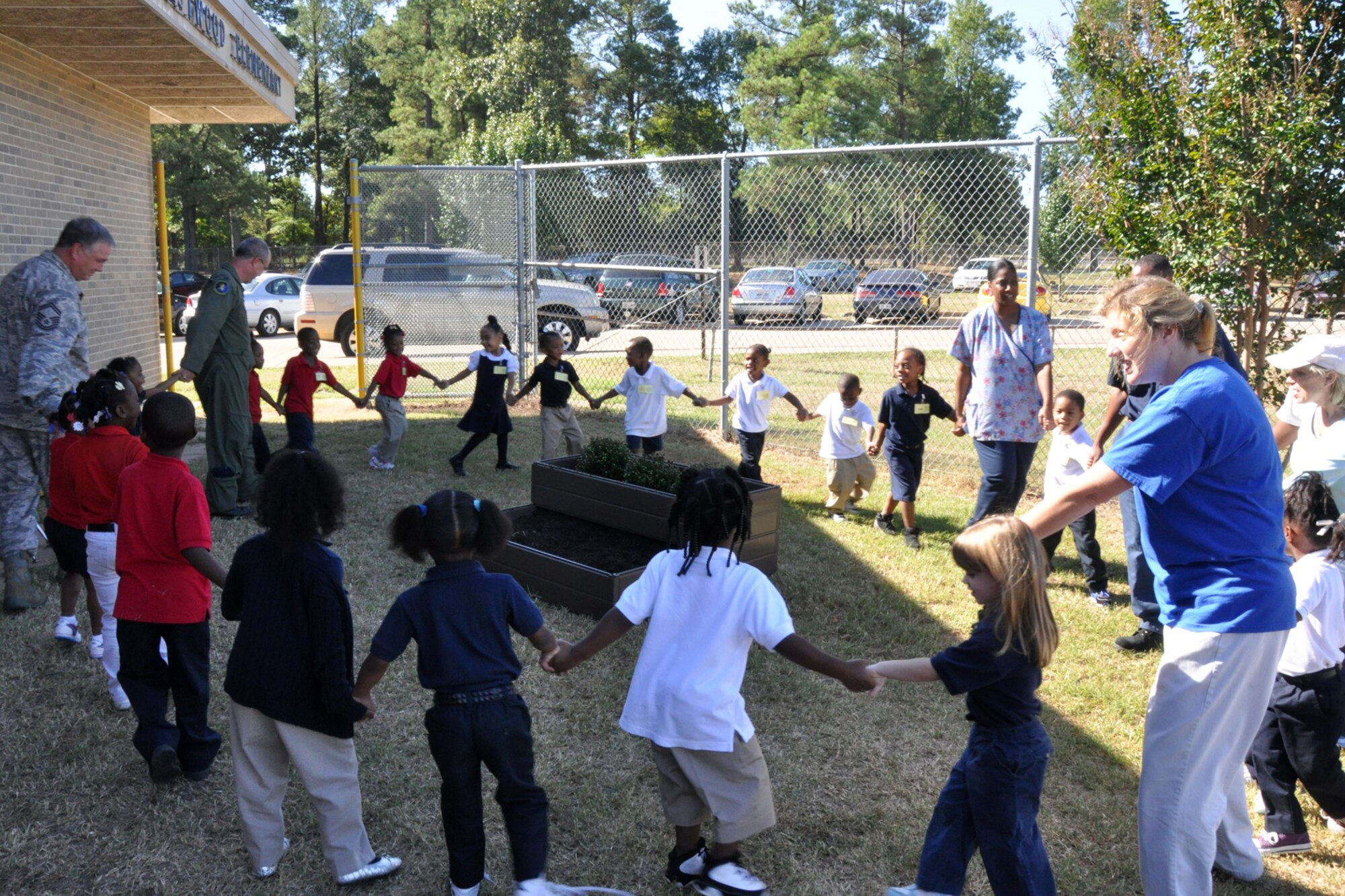 Lt. Col. David Webb, commander of the 917th Operations Support Flight, and Senior Master Sgt. J. Womack, aircrew flight equipment superintendent for the 917th OSF, at Barksdale Air Force Base, La., join a group of Pre-K students at Westwood Elementary School in Shreveport, La., in a happy dance after planting flowering bushes for the class, Sept. 28, 2010. Westwood Pre-K teacher, Mrs. Valli Webb planned the planting project to allow her students the opportunity to see the growth of their efforts.  Through the year, plans are to replace the flowers with seasonal plants and vegetables to be a continuing lesson for the students that could last a lifetime. Westwood Elementary supports children from Pre-K through 5th Grade. (U.S. Air Force photo/Tech. Sgt. Jeff Walston)

