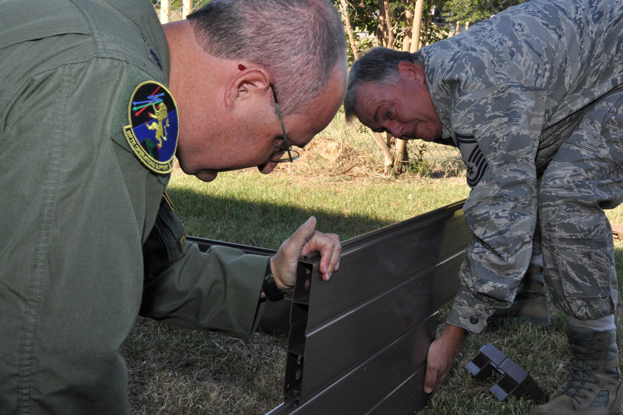 Lt. Col. David Webb, commander of the 917th Operations Support Flight, and Senior Master Sgt. J. Womack, aircrew flight equipment superintendent for the 917th OSF, at Barksdale Air Force Base, La., attempt to assemble a portable flower bed at Westwood Elementary School in Shreveport, La., Sept. 28, 2010. Westwood Pre-K teacher, Mrs. Valli Webb planned the planting project to allow her students the opportunity to see the growth of their efforts. Through the year, plans are to replace the flowers with seasonal plants and vegetables to be a continuing lesson for the students that could last a lifetime. Westwood Elementary supports children from Pre-K through 5th Grade. (U.S. Air Force photo/Tech. Sgt. Jeff Walston)
