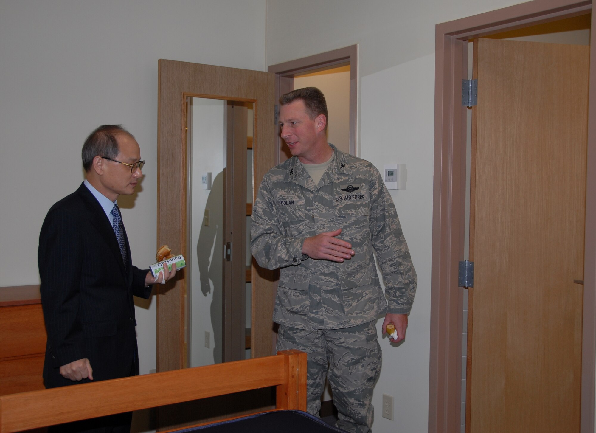 KUNSAN AIR BASE, Republic of Korea -- Col. John Dolan, 8th Fighter Wing commander, explains how much Airmen will appreciate their new rooms in dormitory Bldg. 617 to Yang Sunk-Sok, director of Lotte Construction Company, after the building was officially opened during a ceremony Sept. 29. The dorm will house 160 Wolf Pack Airmen and was under construction from November 2008 to September 2010. (U.S. Air Force photo/Staff Sgt. Amanda Savannah)