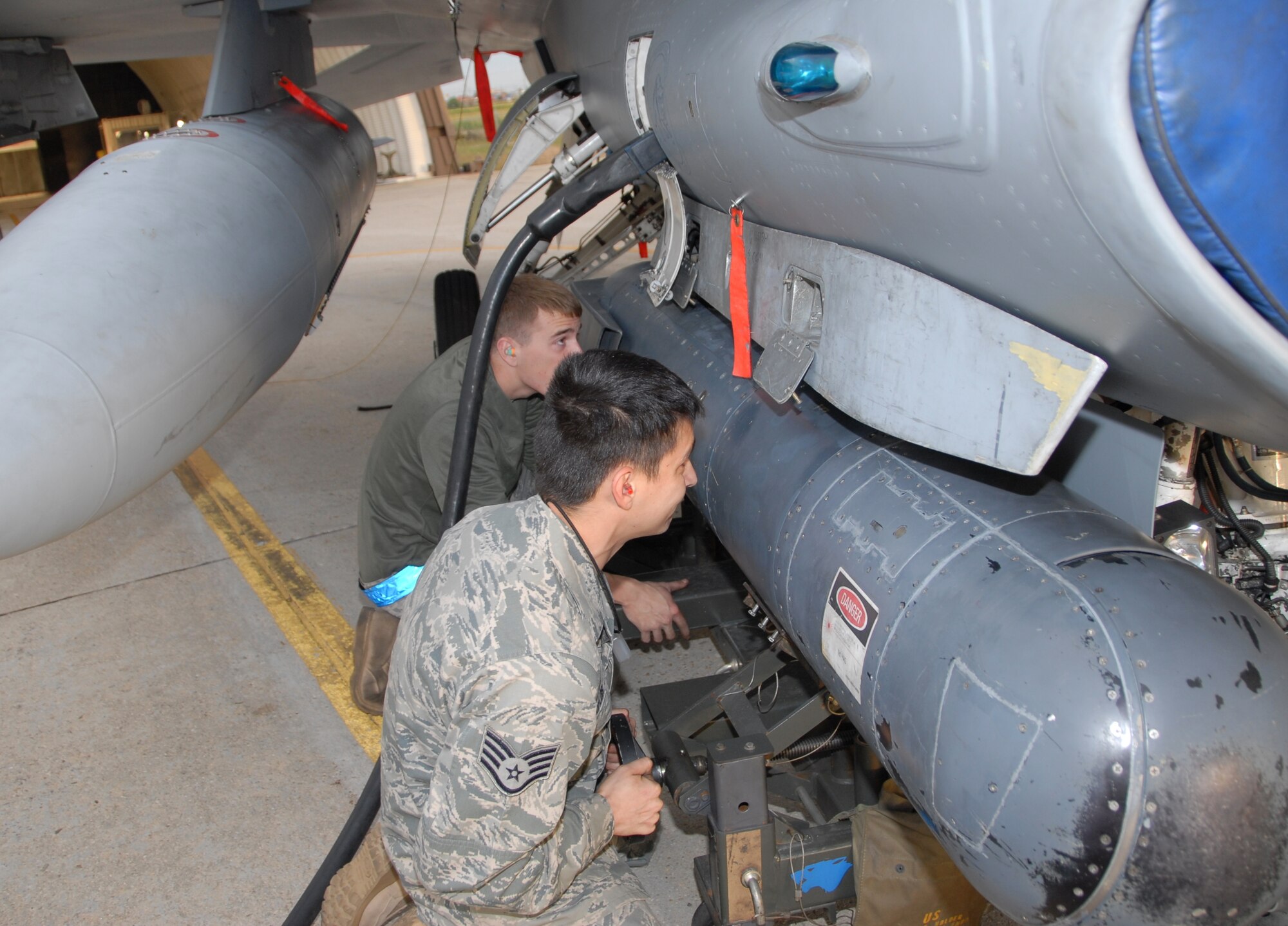 KUNSAN AIR BASE, Republic of Korea -- Airman First Class Kurtis Petty and Staff Sgt. Travis Taylor, 8th Aircraft Maintenance Squadron 35th Aircraft Maintenance Unit avionics system maintainers, hang a targeting pod on an F-16 Fighting Falcon. The 8th AMXS maintainers were crucial to the 8th Fighter Wing zeroing out its flying hour program for 2010. (U.S. Air Force photo/Staff Sgt. Amanda Savannah)