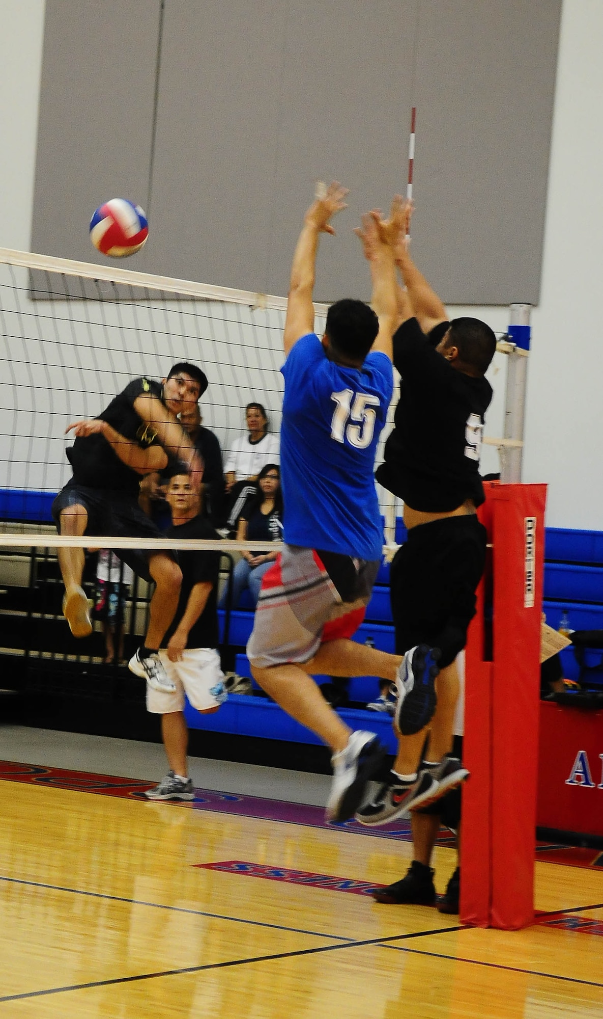 A member of the 734th Air Mobility Squadron volleyball team spikes the ball past two members of the 254th Air National Guard during the 2010 Intramural Volleyball Championship Sept. 24, at the Coral Reef Fitness Center. The 254th team was crowned champions after narrowly defeating the 734th, 2-1. (U.S. Air Force photo/Airman Julian North)