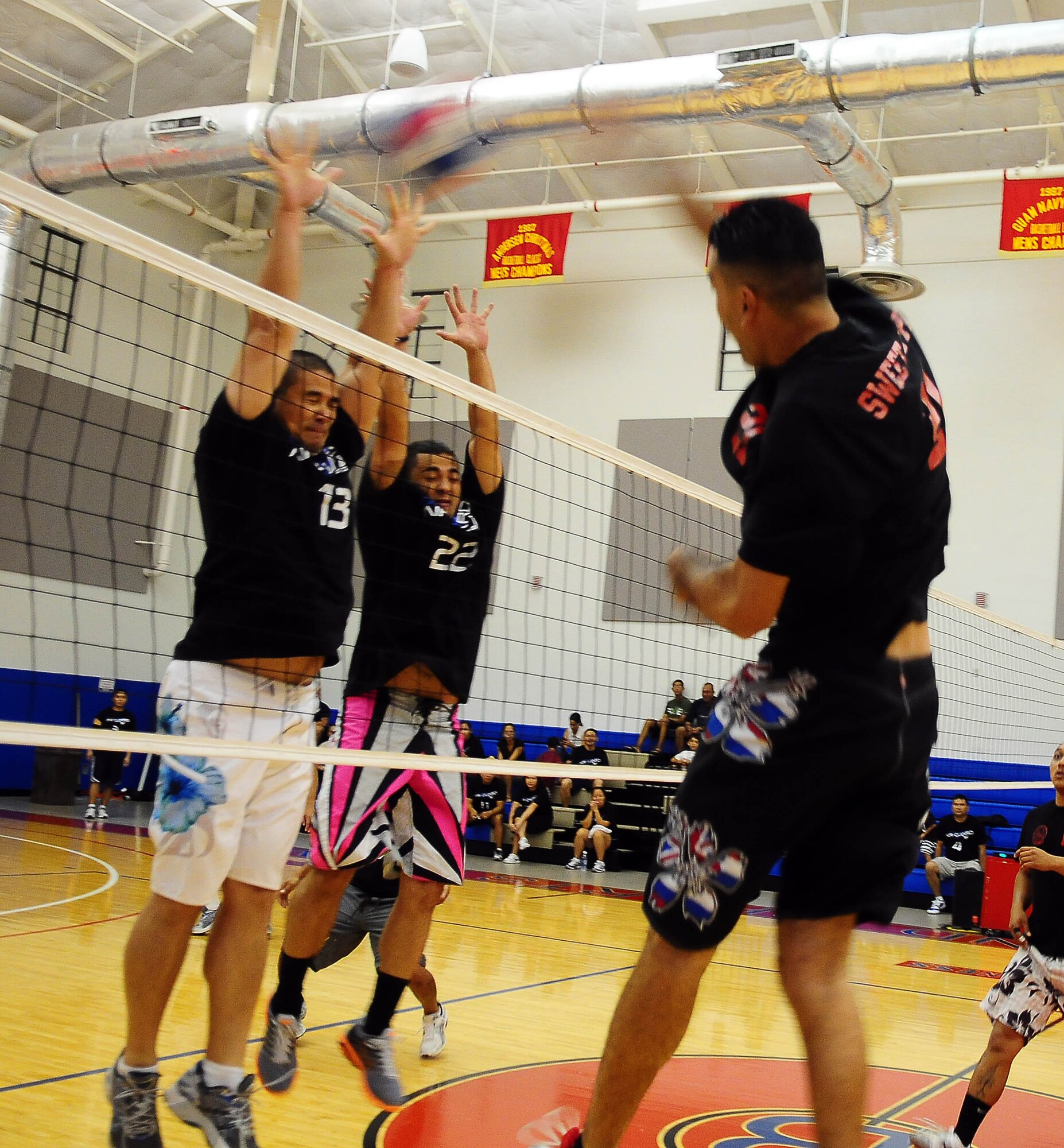 A member of the 734th Air Mobility Squadron volleyball team spikes the ball past two members of the 254th Air National Guard during the 2010 Intramural Volleyball Championship Sept. 24, at the Coral Reef Fitness Center. The 254th team was crowned champions after narrowly defeating the 734th, 2-1. (U.S. Air Force photo/Airman Julian North)