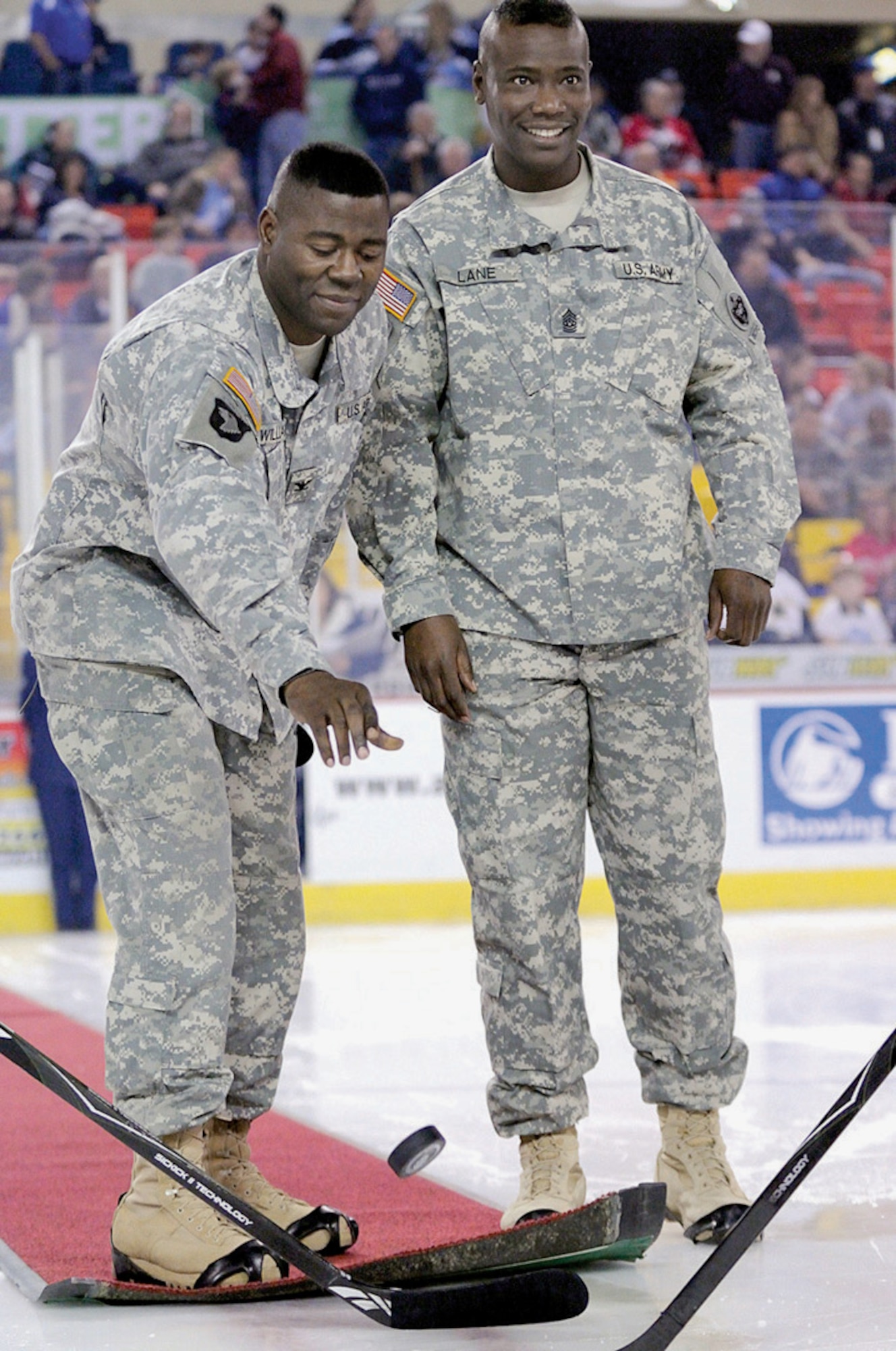 Col. Barry Williams, 3rd Maneuver Enhancement Brigade commander, and Command Sgt. Maj. Charlie Lane, 3rd MEB command sergeant major, drop the ceremonial puck before a Dec. 11, 2009, game between the Aces and the Stockton Thunder. Williams thanked the community for their continued support of the military. (U.S. Air Force photo/David Bedard)