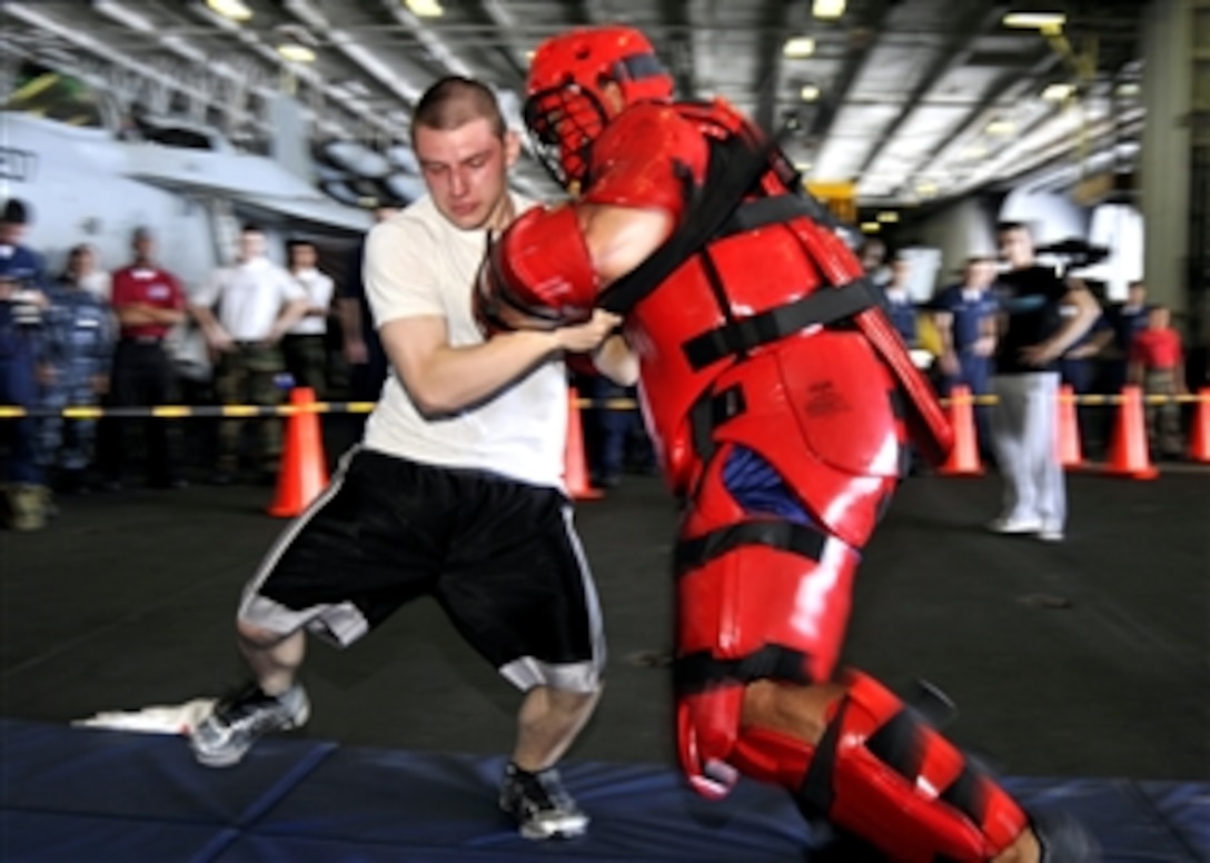 U.S. Navy Airman Kyle Babcock performs a defensive strike technique after being sprayed with oleoresin capsicum, also known as pepper spray, aboard the aircraft carrier USS George Washington (CVN 73) while underway in the Pacific Ocean on Sept. 26, 2010.  Oleoresin capsicum spray training gives sailors experience in dealing with situations they might face as part of the ship’s security reaction force.  