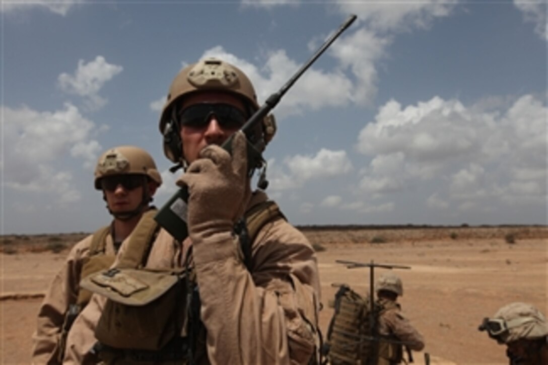 U.S. Marine Corps Capt. Jeffery Wright (2nd from left), with Air Naval Gunfire Liaison Company, 26th Marine Expeditionary Unit, uses a radio during an aircraft and personnel recovery exercise in Djibouti on Sept. 24, 2010.  The 26th Marine Expeditionary Unit is supporting relief operations in Pakistan.  