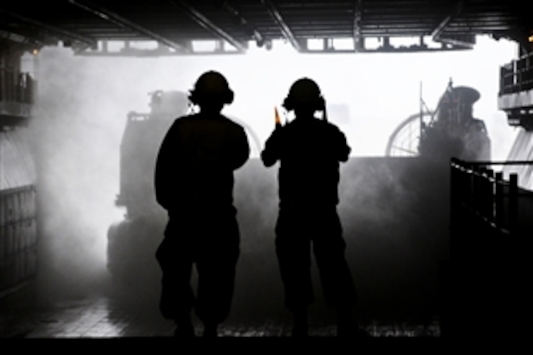 U.S. Navy sailors aboard the amphibious assault ship USS Bataan recover a landing craft air cushion as it approaches the ship's well deck in the Atlantic Ocean, Sept. 28, 2010. 