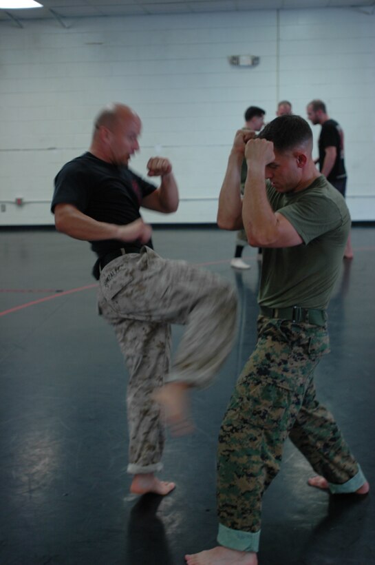 Capt. Craig Schnappinger, right, series commander, 2nd Recruit Training Battalion, blocks his face as Staff Sgt. David Gonzalez, martial arts instructor, Company G, 2nd Recruit Training Bn., prepares to use one of the new strikes they were taught by the Victory Fitness Center’s instructors here, Oct. 1.