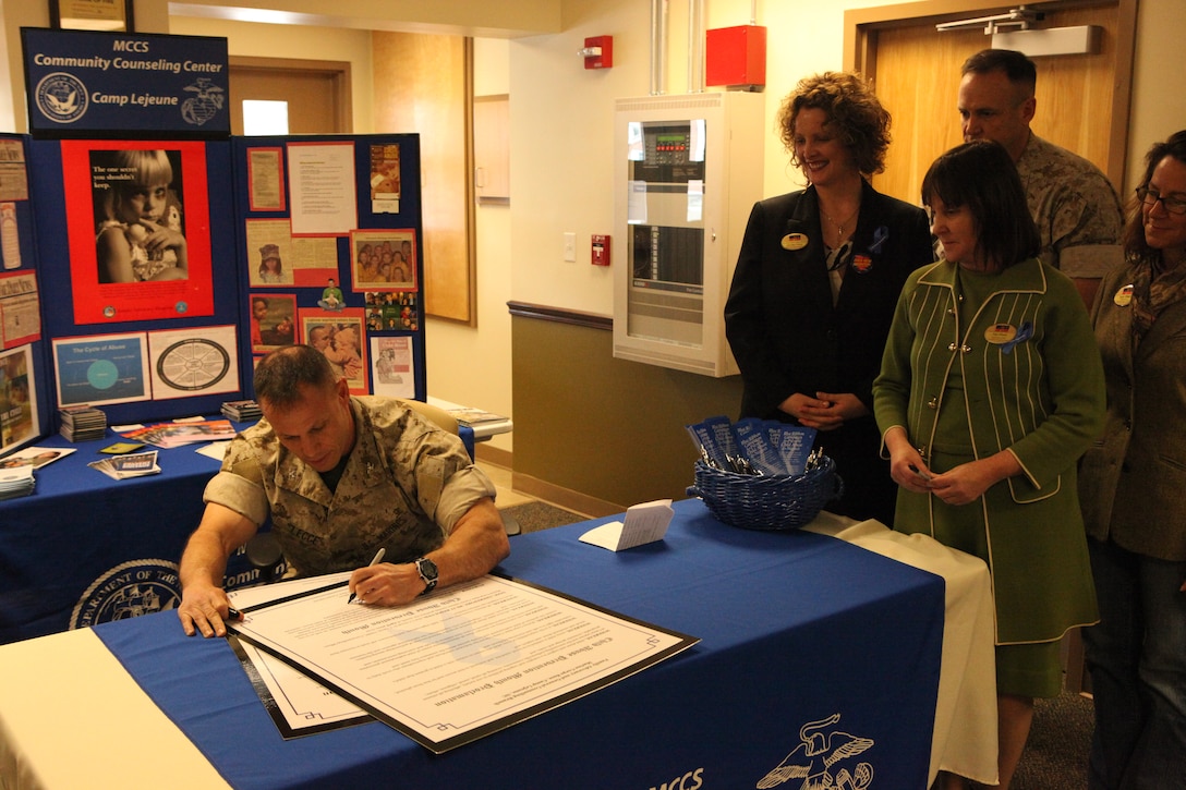 Col. Daniel J. Lecce, commanding officer of Marine Corps Base Camp Lejeune, signs the proclaimation of April as Child Abuse Awareness Month during a ceremony at the Commander Springle Training Center, April 1. April is now officially used by the base's education and intervention specialists, who set up informational booths and offer unit training on child abuse, while providing resources and information for the community and the commands.