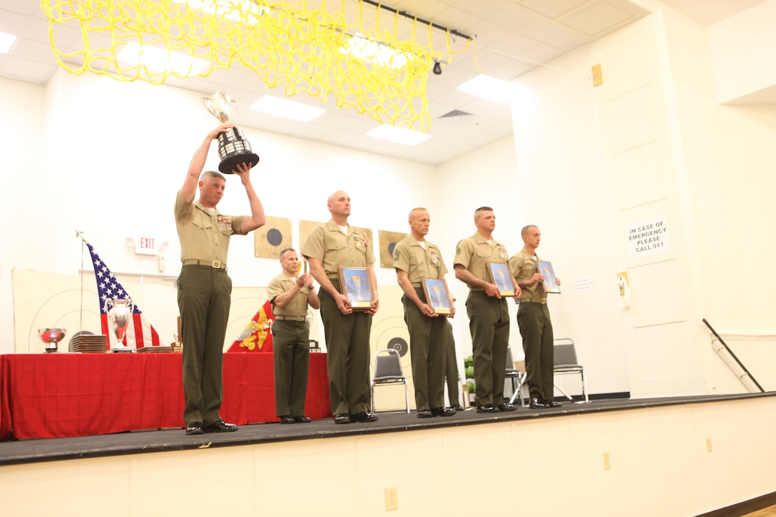 (From left to right)::r::::n::Weapons Training Battalion’s Staff Sgt. Alan E. Nichols, Chief Warrant Officer-3 Peter Burns, Gunnery Sgt. Darrell A. Nash, Sgt. Shaun M. Baer and Lance Cpl. Dennis F. Pate stand recognized in front of their peers April 1, at the Stone Bay Gymnasium after winning the Marine Corps Base Camp Lejeune 2011 Easter Division Match Championship. Weapons Training Battalion narrowly escaped Marine Corps Recruit Depot Parris Island during the Eastern Division Match. Sixteen rifle and pistol teams from the east coast, to include the British Royal Marines, participated in the annual Competition-in-Arms Program event.::r::::n::