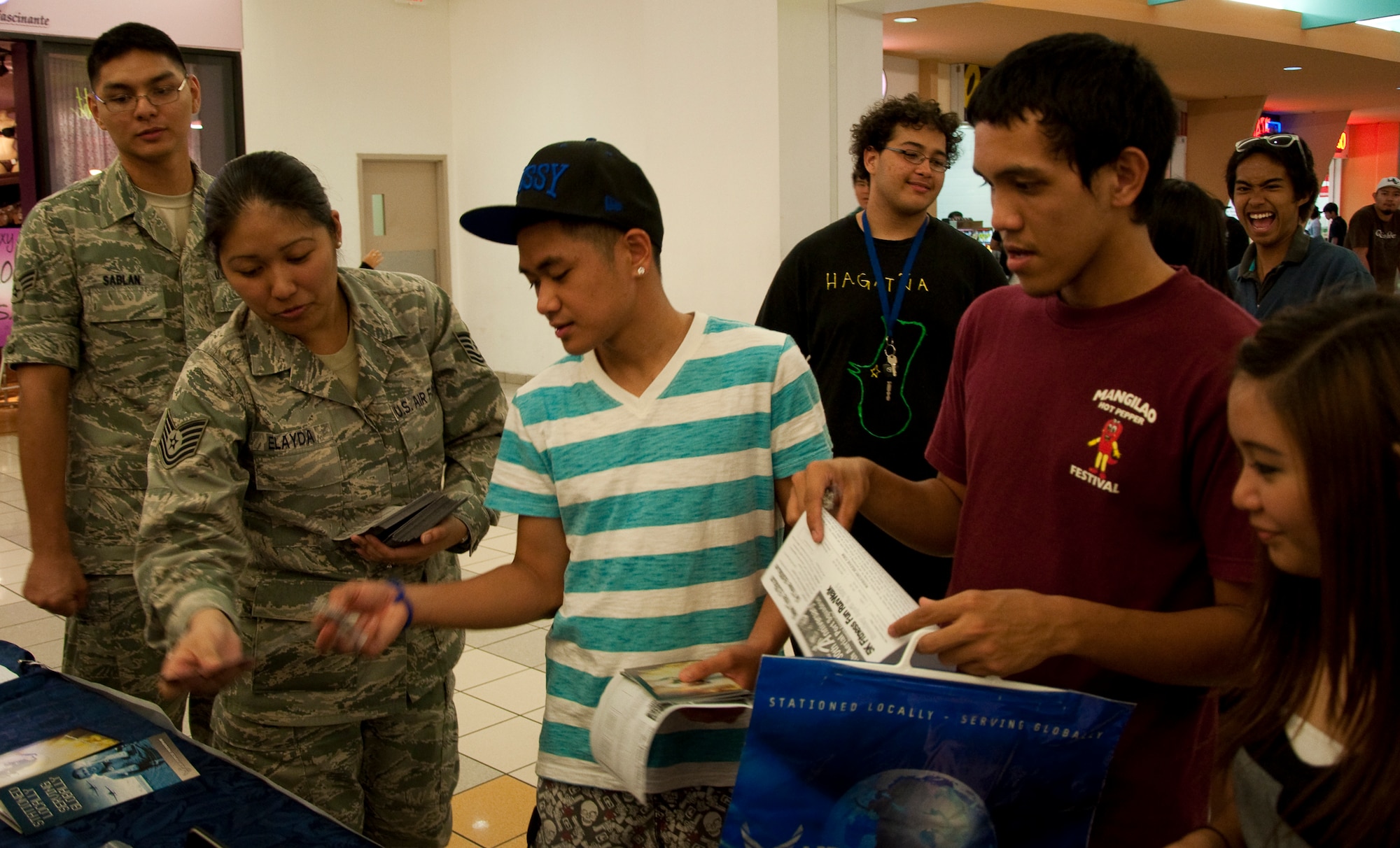 Tech. Sgt. Desyree Elayda hands Air Force Reserve brochures to local teens at the informational and drug demand reduction display at the Guam Micronesia Mall, March 24-25. The display, set up by members of the 44th Aerial Port Squadron and 724th Aeromedical Staging Flight, was part of the 30th Anniversary celebration and Month of the Air Force Reserve on Guam. (U.S. Air Force Photo/Staff Sgt. Erin Smith)

