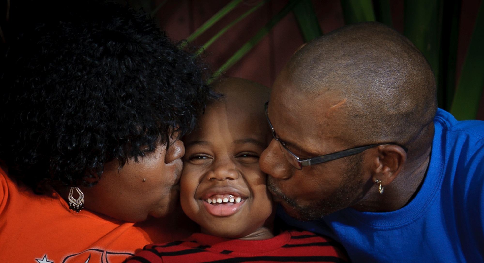 Grammy and Grampy (GP) lay a big kiss on their grandson while relaxing on a backyard swing. Nathaniel?s parents appointed Ronald and Carol Lee as their son?s legal guardians. Raising Nathaniel has helped them deal with the grief of losing their daughter and son-in-law.(Photo by Samuel Bendet)