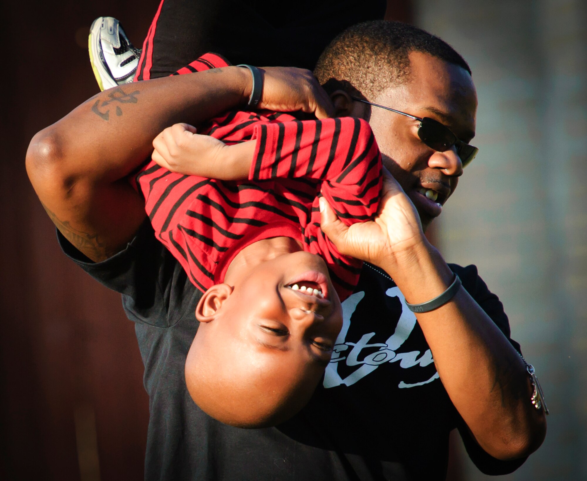 ?Uncle Face? ? or Staff Sgt. Aron Lee ? plays football with Nathaniel in the back yard. Lee got a humanitarian assignment to Lackland AFB, Texas, to help his parents raise Nathaniel after the tragic deaths of the boy?s mom and dad.
(Photo by TSgt Samuel Bendet)