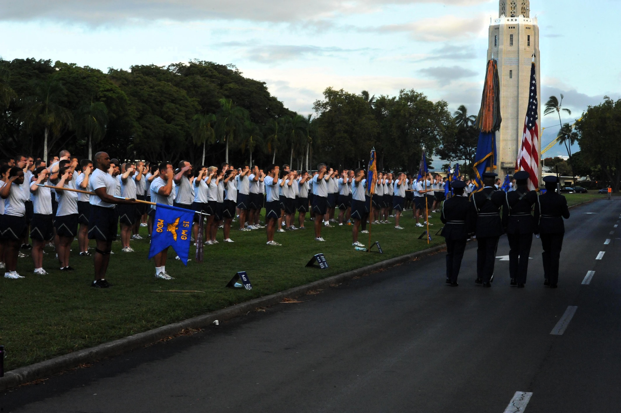 Airmen from Joint Base Pearl Harbor-Hickam, Hawaii, present arms to the colors as they prepare for the monthly "Warrior Run" Apr. 1 which begins and ends at Hickam Mall. The run, which spans approximately two miles, was hosted this month by the 15th Medical Group. (U.S. Air Force photo by Staff Sgt. Nathan Allen)