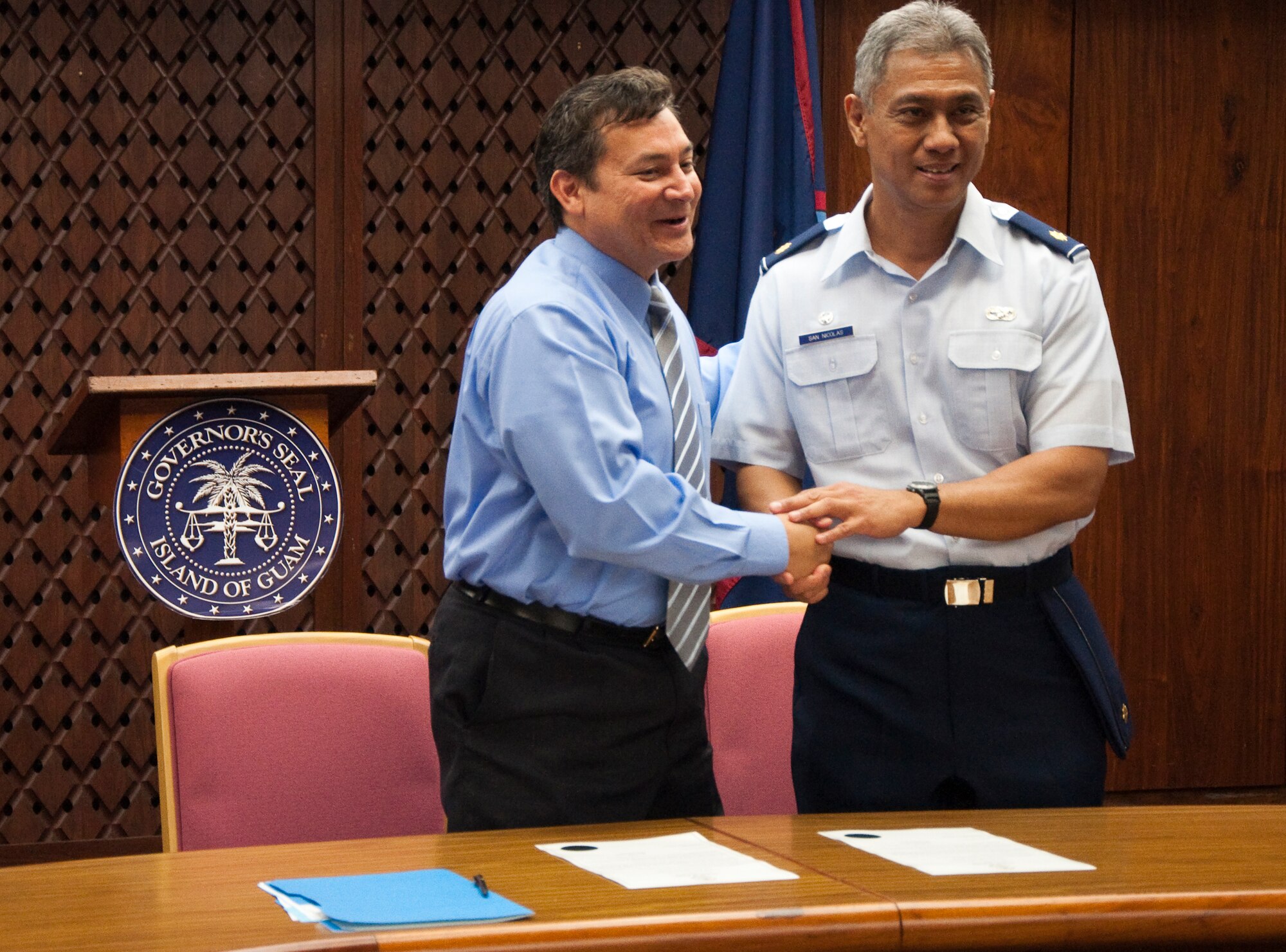 Gov. Edward B. Calvo, Guam governor, shakes hands with Maj. Anthony C. San Nicolas, 44th Aerial Port Squadron commander after signing a proclamation designating March as Month of the Air Force Reserve on Guam. The proclamation was signed on the 30th anniversary of the arrival of Air Force Reserve on Guam. U.S. Air Force Photo/Staff Sgt. Erin Smith