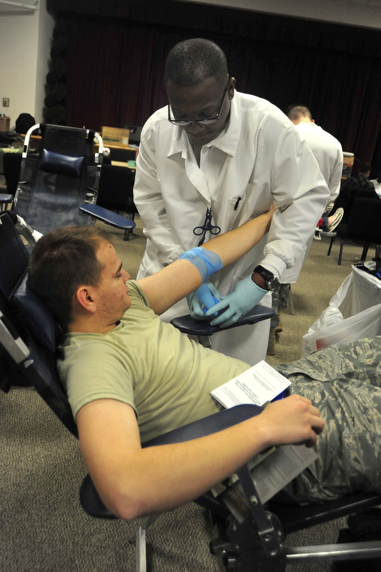 Airman 1st Class Charlie Gladden, left, 62nd Aircraft Maintenance Squadron, gets bandaged up by Specialist Jason Routt, Bravo Company at Madigan Healthcare Facility, after donating blood during an Armed Services Blood Bank Center blood drive March 30 at Joint Base Lewis-McChord, Wash. All donations are sent to support deployed servicemembers in Iraq and Afghanistan within two weeks. (U.S. Air Force photo/Airman 1st Class Leah Young)