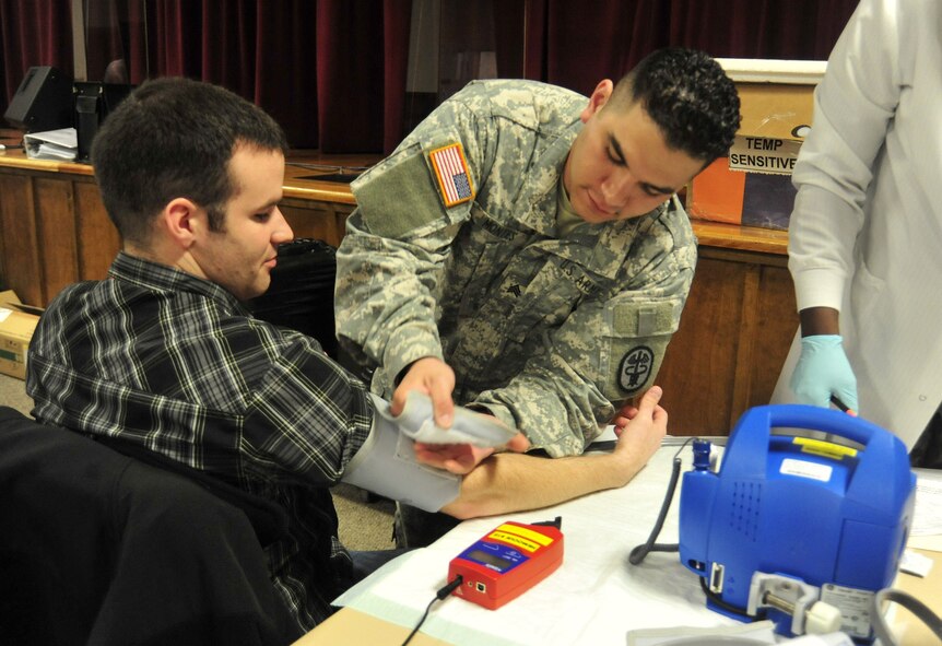 Adam Passmore, left, prepares to have his blood pressure taken by Sergeant Rico Montes, Bravo Company at Madigan Healthcare Facility, during an Armed Services Blood Bank Center blood drive March 30 at Joint Base Lewis-McChord, Wash. All donations are sent to support deployed servicemembers in Iraq and Afghanistan within two weeks. (U.S. Air Force photo/Airman 1st Class Leah Young)