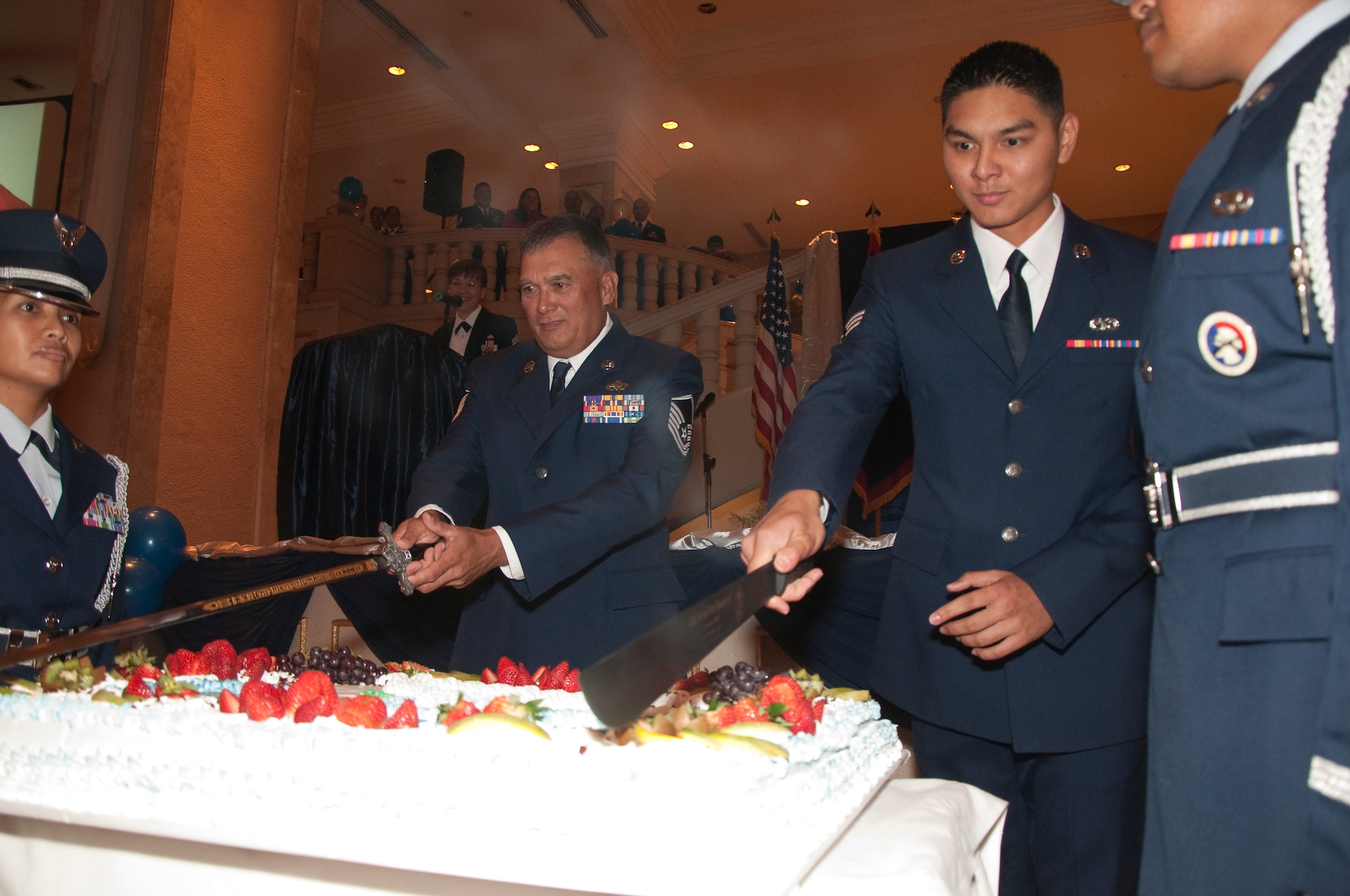 Master Sgt. Gian Tenorio and Senior Airman Josh Sablan, the 44th Aerial Port Squadron's oldest and youngest member, cut the 30th Anniversary cake during the 44th Aerial Port Squadron's 30th Anniversary Banquet, March 26, at the Holiday Resort and Spa, Tumon Guam. (U.S. Air Force Photo/Staff Sgt. Erin Smith)