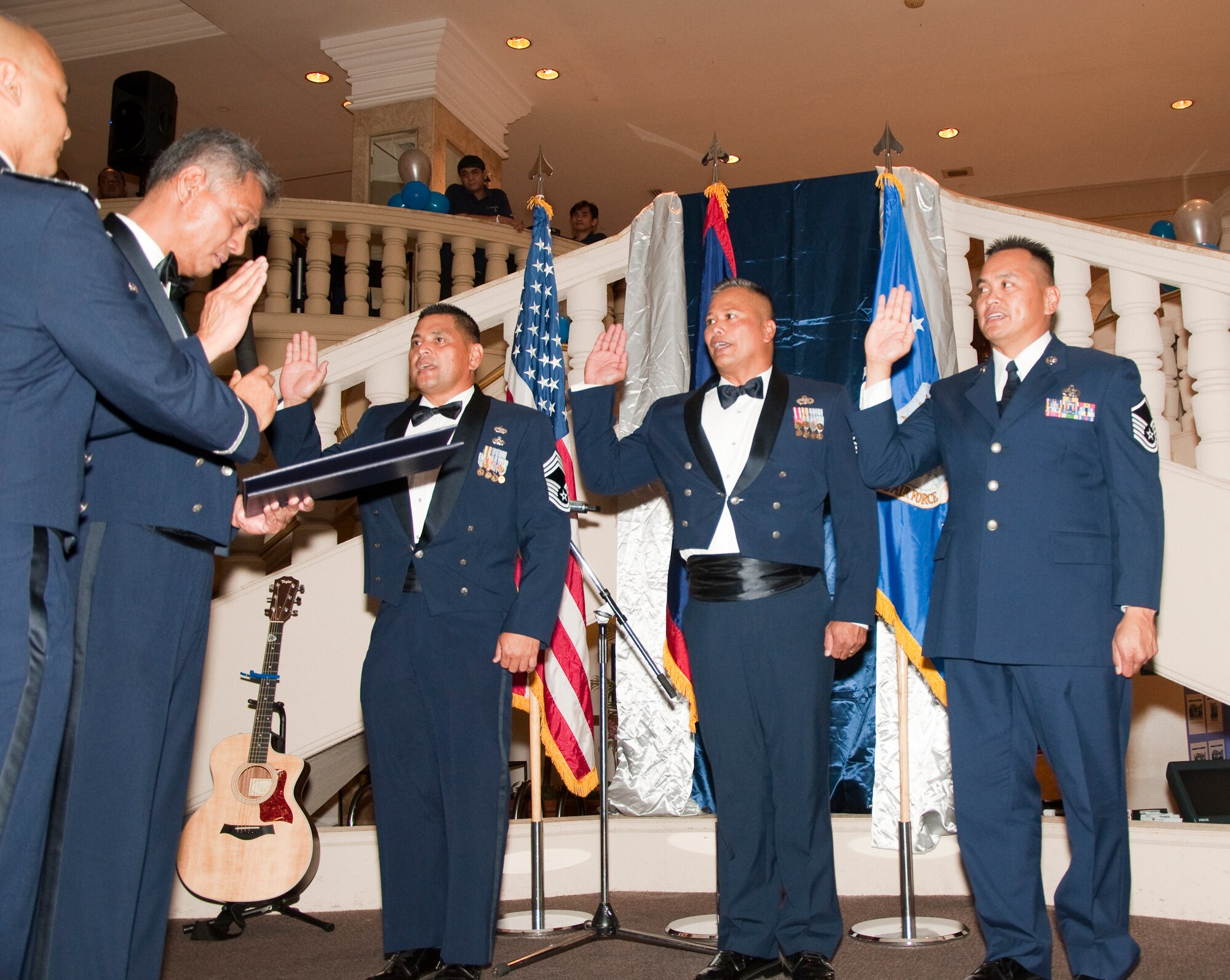 Maj. Anthony San Nicolas, 44th Aerial Port Squadron commander, administers the oath of enlistment to Chief Master Sgt. Maurice Sayama, Senior Master Sgt. Glenn San Nicolas and Master Sgt. Phillip Ada, 44th Aerial Port Squadron, as they reenlist during the Squadron's 30th Anniversary Banquet, March 26. The Banquet marks 30 years of the Air Force Reserve on Guam. (U.S. Air Force Photo/Staff Sgt. Erin Smith)