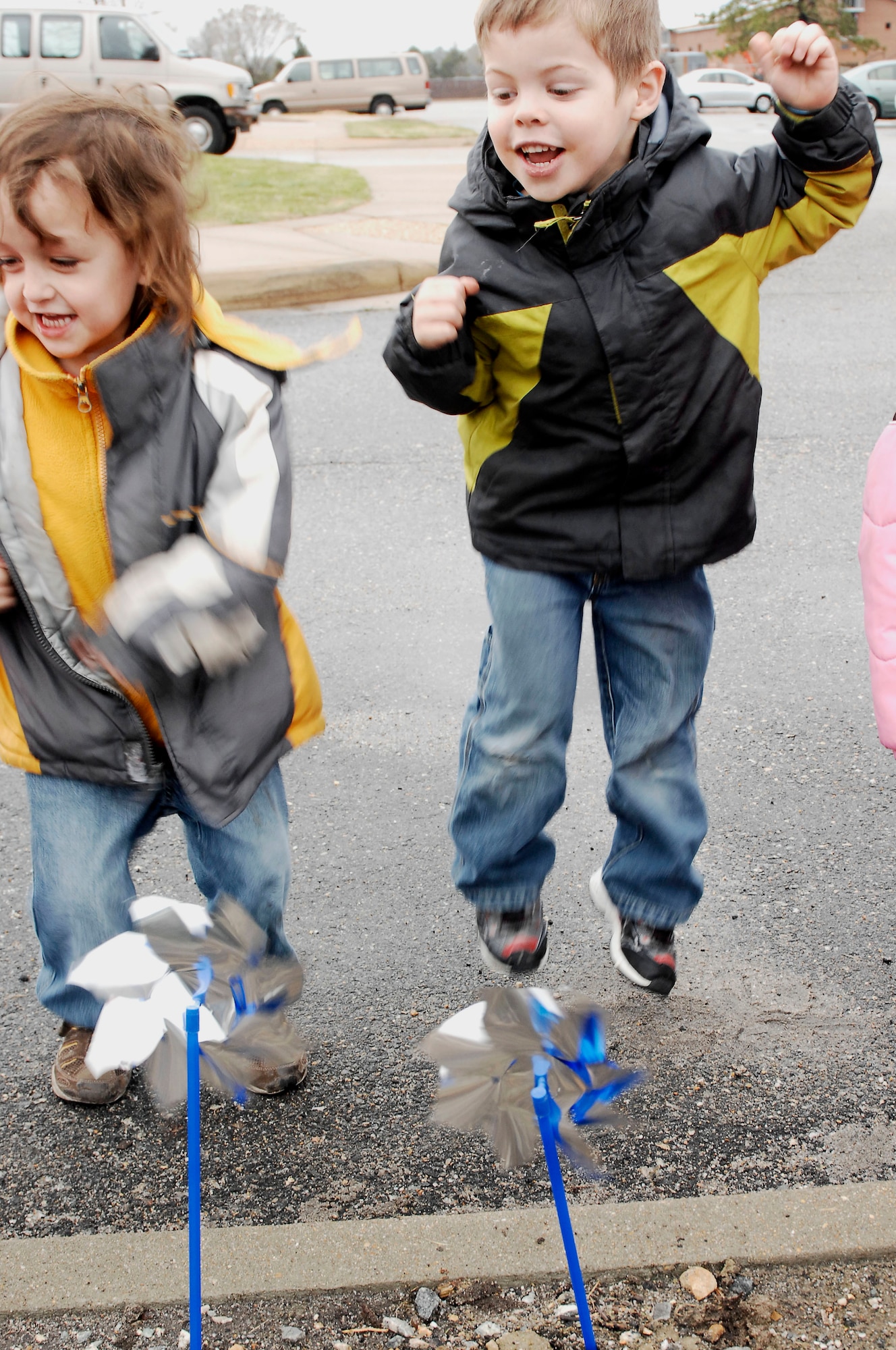 Four year old Ryan Davis, son of Staff Sgt. Heidi Davis 633d Air Base Wing Public Affairs, cheers on his spinning pinwheel after planting it outside  the Child Development Center at Langley Air Force Base, Va., April 1, 2011. Each pinwheel planted honors a child who deserves to be loved during Child Abuse Prevention month and month of the military child. (U.S. Air Force photo by Airman 1st Class Kayla Newman/ Released)