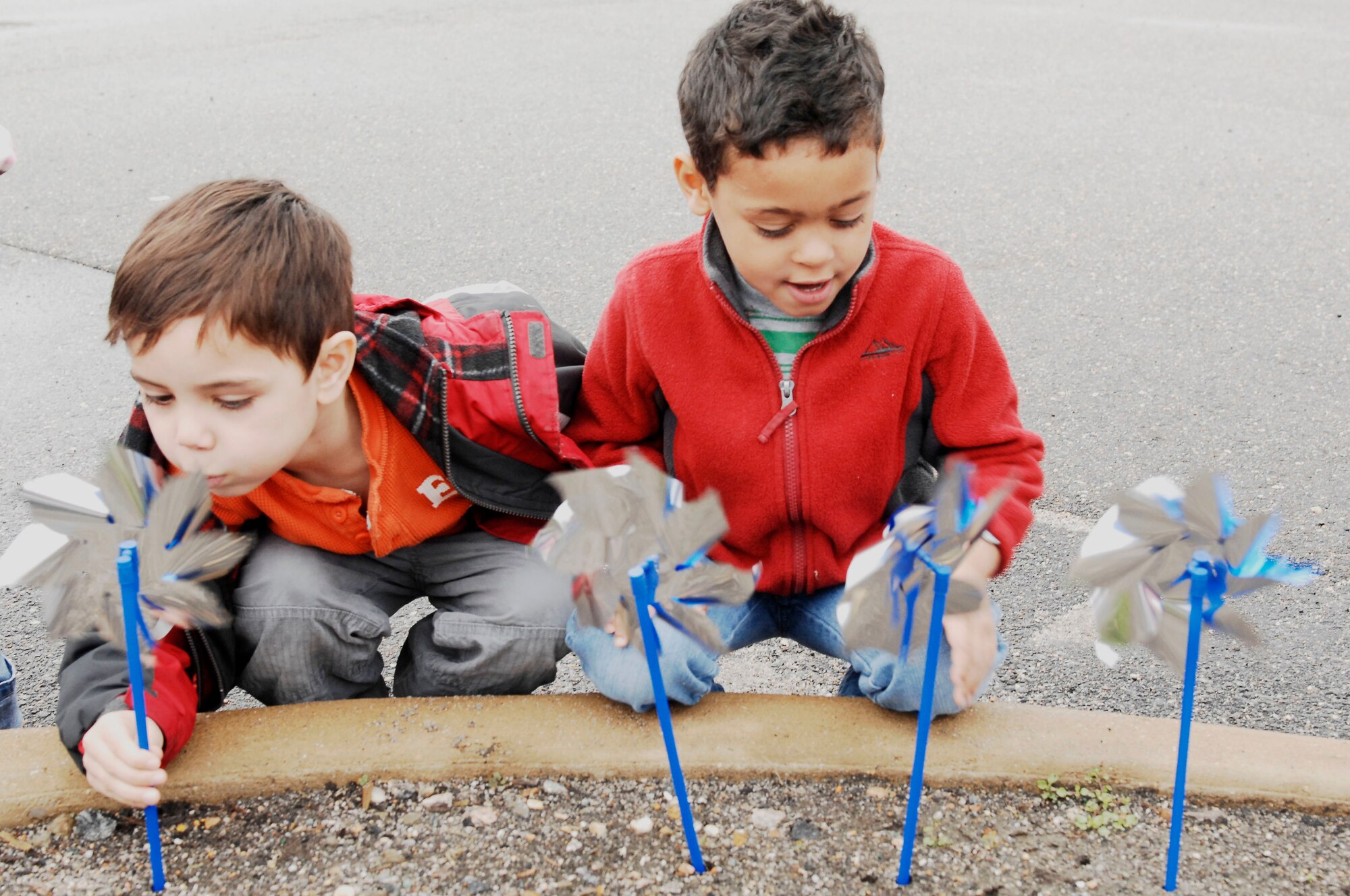 Five year olds Joseph Todd, son of Tech. Sgt. Cherrylanda Todd, and Alexavier Smith, son of Staff Sgt. Eleana Beckman, plant pinwheels outside the Child Development Center at Langley Air Force Base, Va., April 1, 2011. April is Child Abuse Prevention month as well as Month of the Military Child and each pinwheel represents a child who deserves to be loved. (U.S. Air Force photo by Airman 1st Class Kayla Newman/ Released)