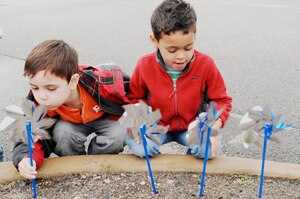 Five year olds Joseph Todd, son of Tech. Sgt. Cherrylanda Todd, and Alexavier Smith, son of Staff Sgt. Eleana Beckman, plant pinwheels outside the Child Development Center at Langley Air Force Base, Va., April 1, 2011. April is Child Abuse Prevention month as well as Month of the Military Child and each pinwheel represents a child who deserves to be loved. (U.S. Air Force photo by Airman 1st Class Kayla Newman/ Released)