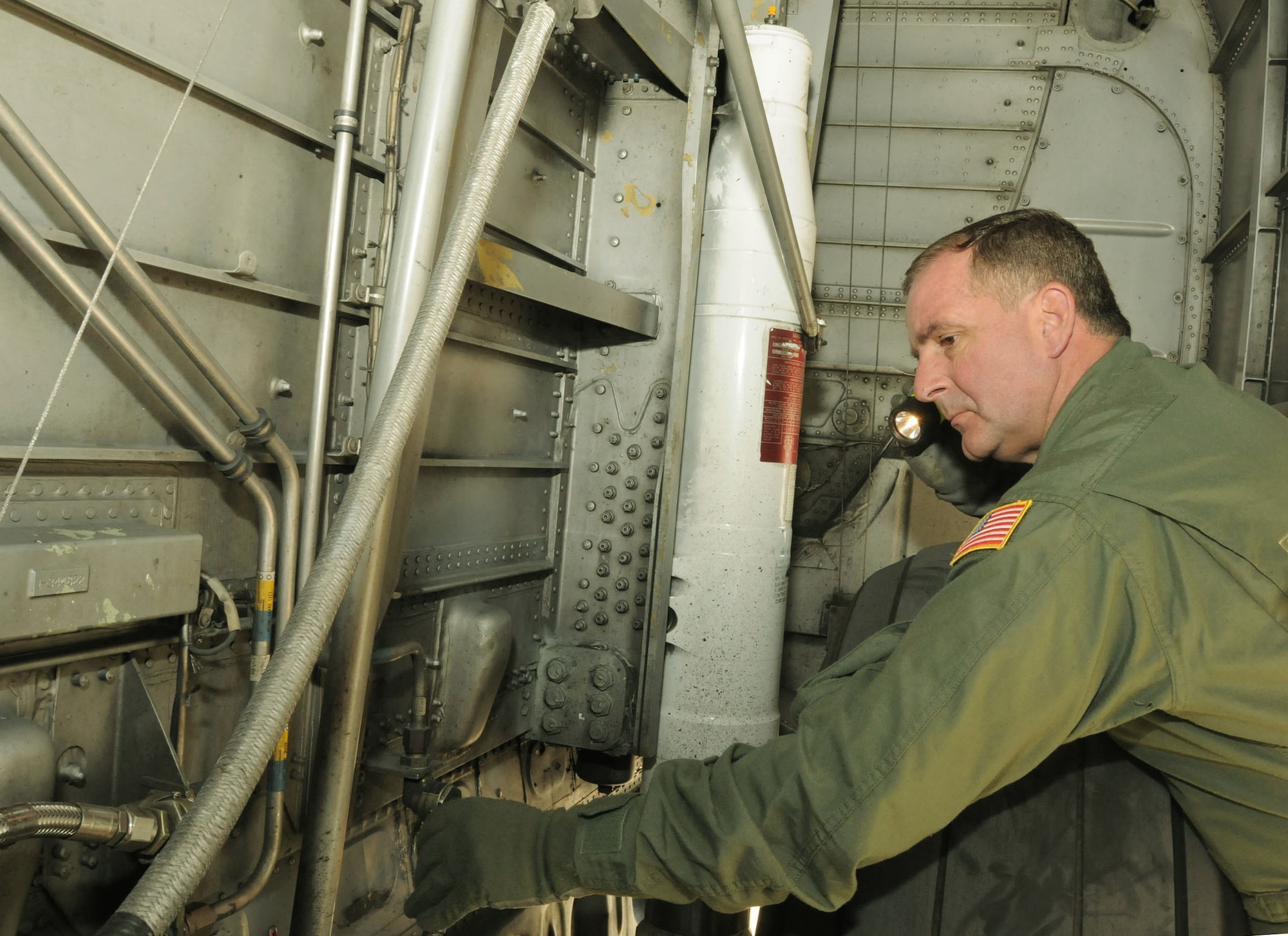 Senior Master Sgt Ron Nester loadmaster for the 115th Airlift Sqadron completes pre-flight checksin the wheel well of a C-130J at the Channel Islands ANGS. Sergeant Nester is the 2010 Outstanding Senior NCO of the Year.