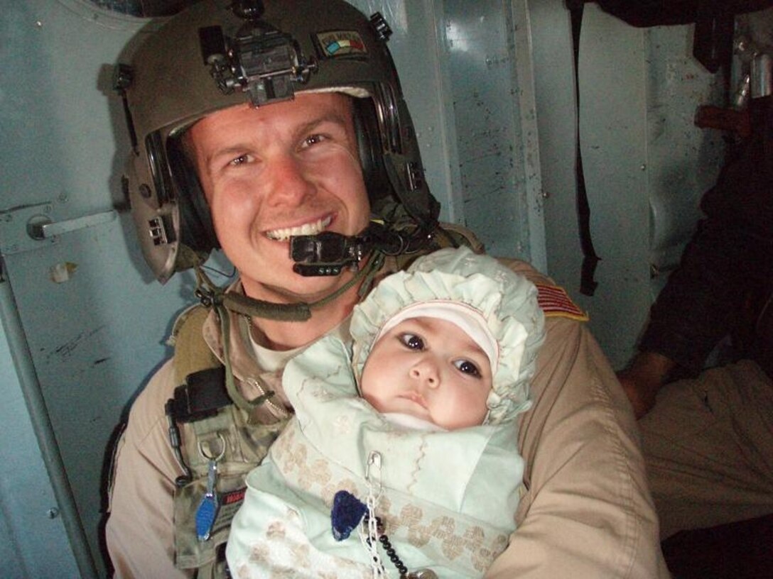 Staff Sgt. Bryan Costerisan, 444th Air Expeditionary Advisory Squadron flight engineer,  is currently deployed to Afghanistan as an MI-17 Examiner flight engineer. He is seen here taking care of a "distinguished visitor" on a flood relief mission. He and our other air advisors are doing medical evacuation, troop movement, forward operating base resupply, and other missions. (Courtesy Photo)