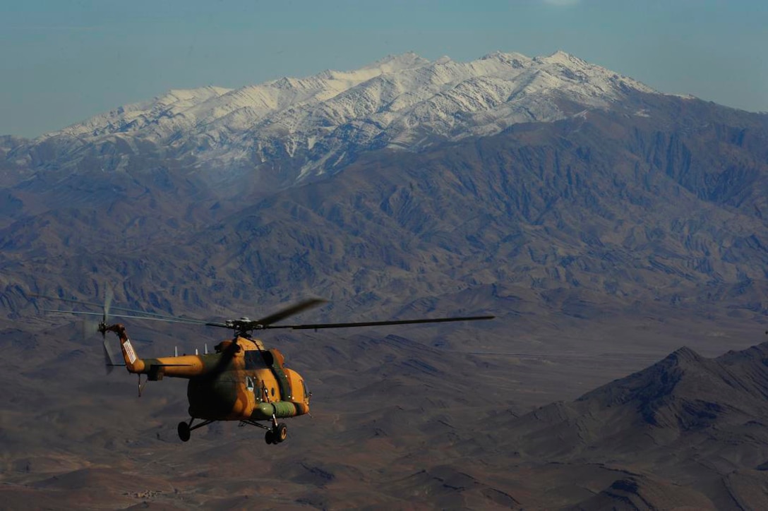 U.S. Air Force Airmen from the 444th Air Expeditionary Advisory Squadron and an Afghan Air Force pilot fly an Mi-17 helicopter during a formation flight at Shindand Air Base, Afghanistan, Feb. 7, 2011.  Formation flying is part of the tactical flying phase of the Afghan pilot training program.  (U.S. Air Force Photo/Staff Sgt. Eric Harris) (RELEASED)