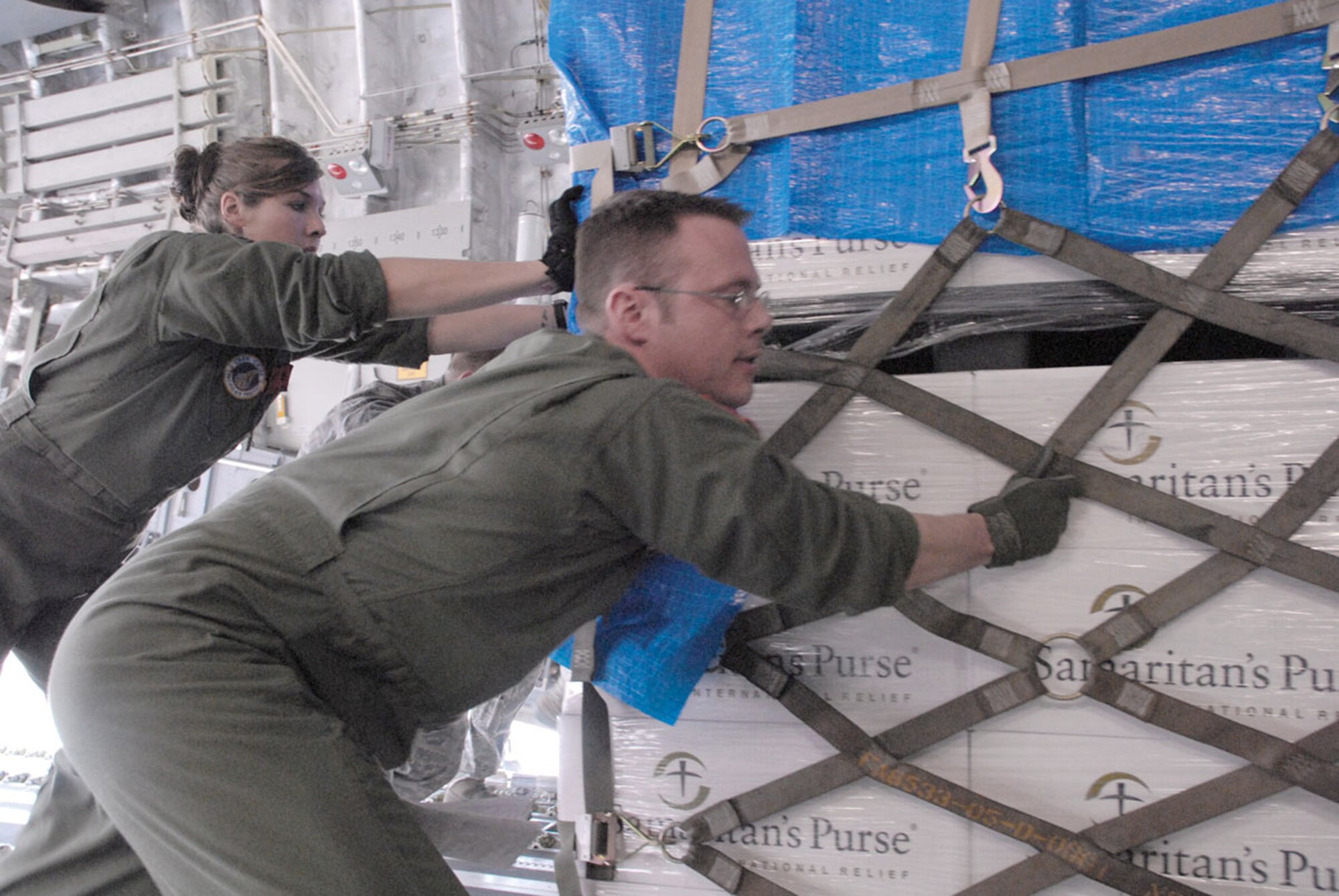Capt. Allen Morris and Staff Sgt. Carol Kemmis help load the first humanitarian relief supplies to be delivered to Sendai, Japan, from Yokota Air Base, Japan, by a C-17 Globemaster III March 20, 2011. Morris is a 517th Airlift Squadron pilot. Kemmis is a 703rd Aircraft Maintenance Squadron crew chief. (U.S. Air Force photo/Staff Sgt. Mark Leahy)