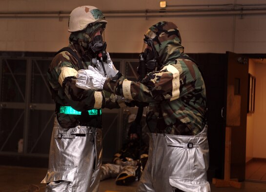 Two Airmen from the 23rd Civil Engineer Squadron fire emergency services flight use a buddy system to ensure their mission oriented protective postures are properly donned during an operational readiness exercise March 30 at Moody Air Force, Ga. The fire emergency services flight has special gear they must don in order to provide support during certain MOPP levels. (U.S. Air Force photo/Airman 1st Class Nicholas Benroth)(RELEASED)