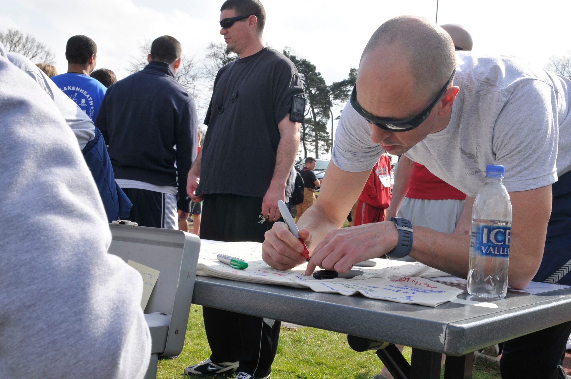 ROYAL AIR FORCE LAKENHEATH, England – Staff Sgt. Robert Abato, 48th Communications Squadron Postal specialist, signs a T-shirt prior to participating in the Phil Myers Memorial Run on April 1, 2011. Sergeant Myers was a member of the 48th Civil Engineer Squadron Explosive Ordnance Disposal Flight who died as a result of an improvised explosive attack while deployed to Afghanistan in 2009. The T-shirt will go to the family members of Sergeant Myers. (U.S. Air Force photo/Senior Airman Tiffany M. Deuel)
