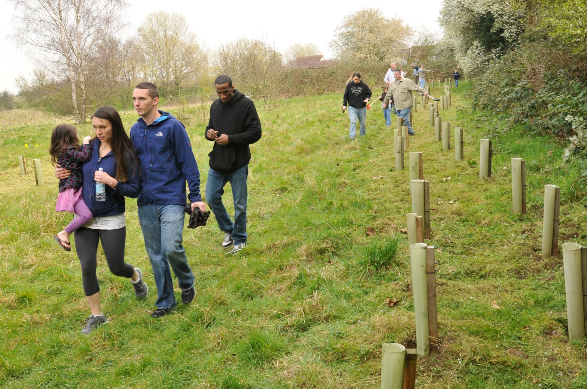 ROYAL AIR FORCE LAKENHEATH, England--Volunteers walk alongside the trees they planted for the Committee of Newmarket in Bloom March 26. Seventeen members of the 48th Aerospace Medicine Squadron and 48th Aircraft Maintenance Squadron planted 100 trees. (U.S. Air Force photo by Senior Airman Eboni Reams)
