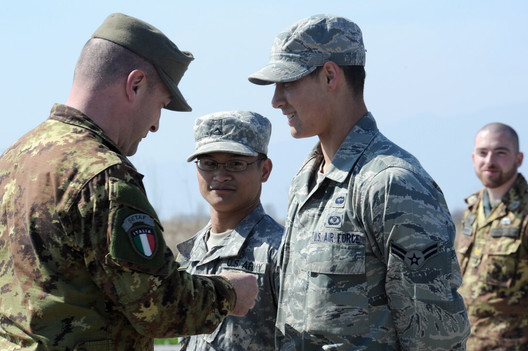 Airman 1st Class Craig Gabrielson, an 8th Air Support Operation Squadron tactical air control party, was honored by Italian Army Sgt. 1st Class Luca Bertozzo during the closing ceremony of a joint coalition training exercise when the paratrooper presented him with a set of wings March 23, 2011, at Aviano Air Base, Italy. (U.S. Air Force photo/Staff Sgt. Nadine Y. Barclay) 