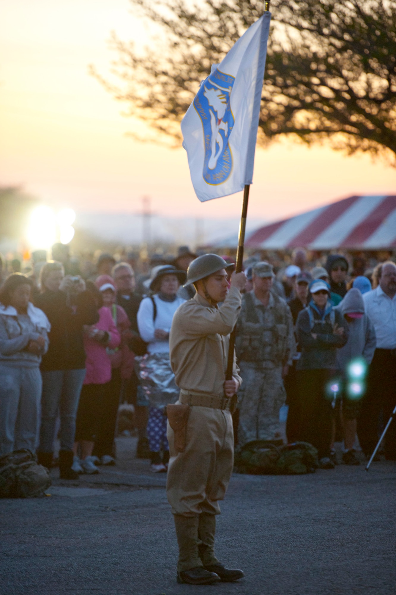 A participant of the 22nd Annual Bataan Memorial Death March holds a flag March 27, 2011 during a moment of silence at White Sands Missile Range, New Mexico. Three remaining survivors attended the opening ceremony. The event, attended by a record number of more than 6,000 marchers, commemorated the original Bataan Death March, which occurred in the Philippines during World War II. (U.S. Air Force photo/Airman 1st Class Joshua Turner) 