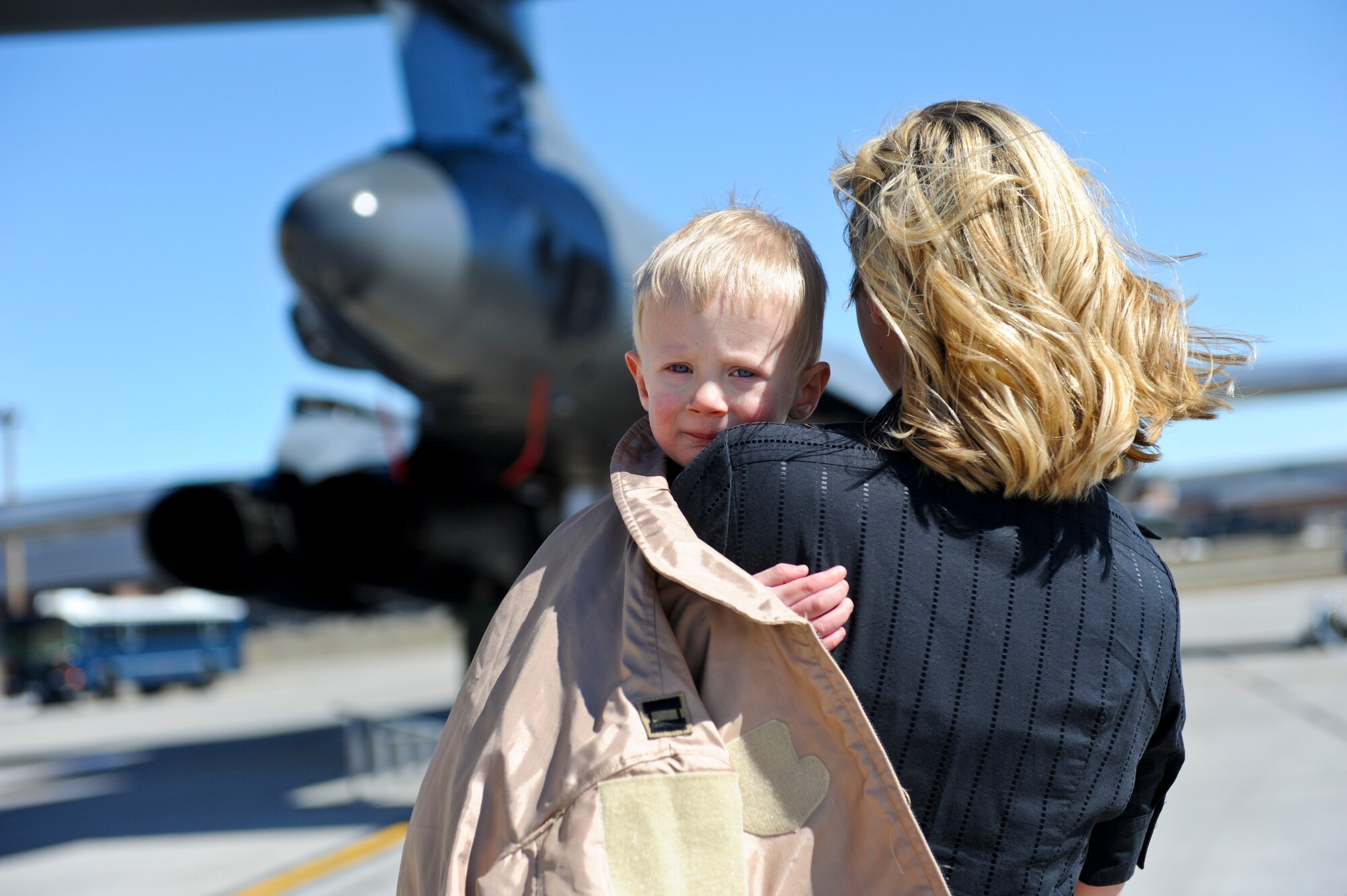 (Right) Lexi Bone and her son Bryce await the arrival of Capt. Dennis Bone, 34th Bomb Squadron Weapon Systems Operator at Ellsworth Air Force Base, S.D., March 30, 2011. The mission was the first in which the B-1 fleet launched combat sorties from the continental United States to strike targets overseas. (U.S. Air Force photo/Senior Airman Adam Grant)