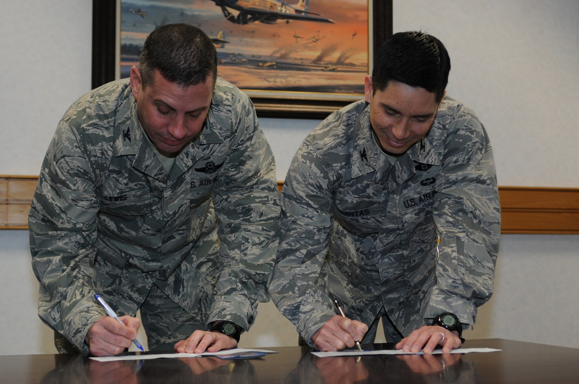 ROYAL AIR FORCE LAKENHEATH, England - Col. William Lewis (left), 48th Fighter Wing vice commander, and Col. John Quintas, 48th FW commander, sign contributions to the 2011 Air Force Assistance Fund on April 1. Contributions to the campaign support the Air Force Aid Society, Air Force Enlisted Village, Air Force Village and the General and Mrs. Curtis E. LeMay Foundation. (U.S. Air Force photo/Airman Cory Payne)