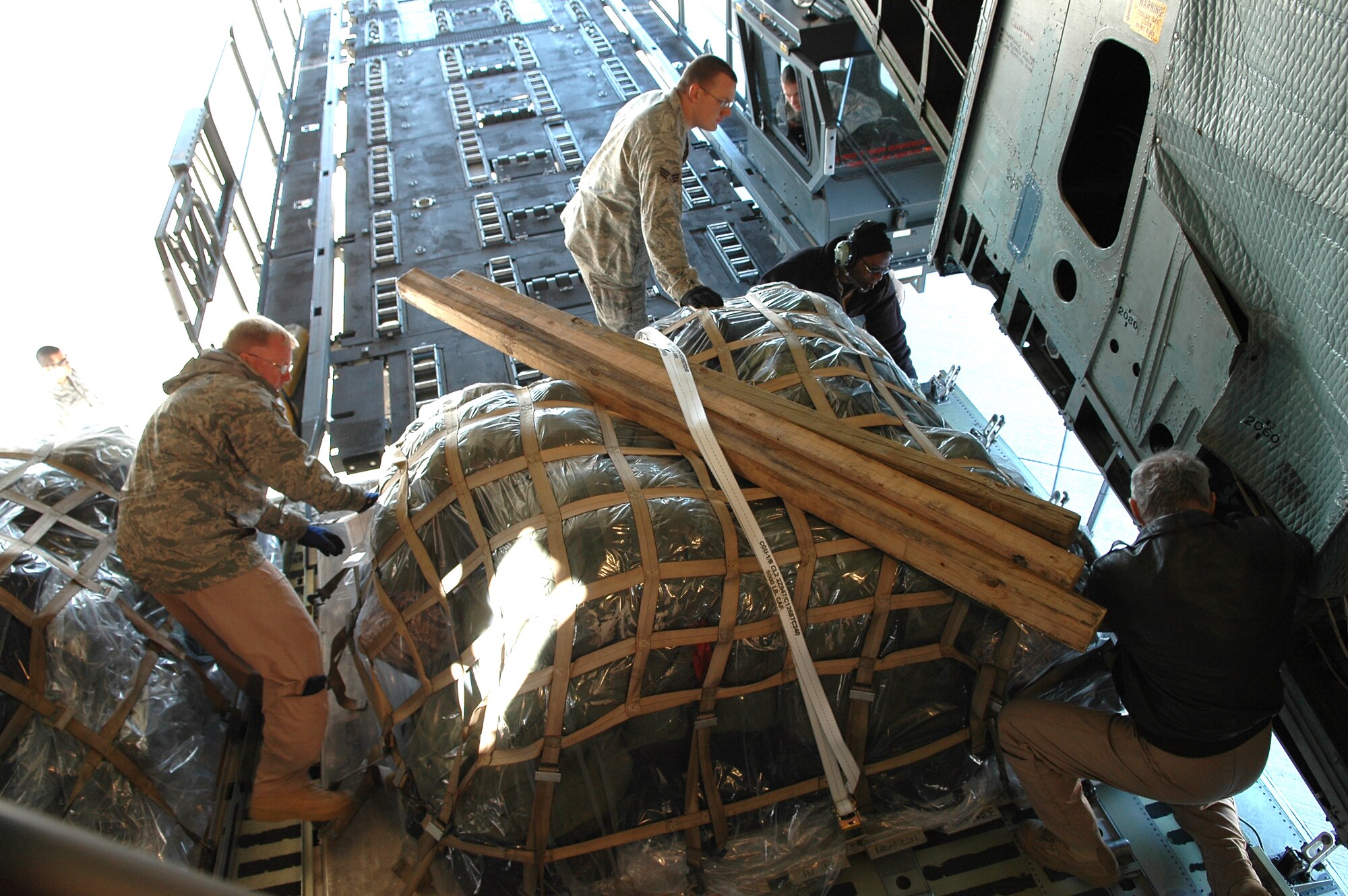 Airmen from the 72nd Logistcs Readiness Squadron and C-5 loadmasters from the 89th Airlift Squadron at Wright Patterson Air Force Base, Ohio, move a pallet from a loader into the cargo bay of a C-5 Globemaster for a 552nd Air Control Wing deployment. (Air Force photo by Micah Garbarino)