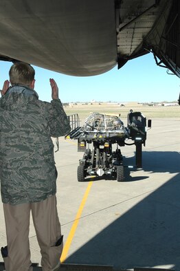 Master Sgt. Dave White, a C-5 loadmaster with the 89th Airlift Squadron at Wright Patterson Air Force Base, Ohio, guides a 72nd Logistics Readiness Squadron vehicle loaded with pallets and driven by 72nd Logistics Readiness Squadron’s Staff Sgt. Mike Harrison. The pallet is bound for an undisclosed location where the 552nd Air Control Wing is deployed in support of Operation Odyssey Dawn.  (Air Force photo by Micah Garbarino)