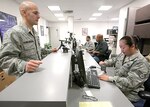 Staff Sgt. Stacie Smith (right), pass and registration section NCO in charge, helps Airman 1st Class Nestor Flores-Negron with his Common Access Card registration March 3. (U.S. Air Force photo/Robbin Cresswell)