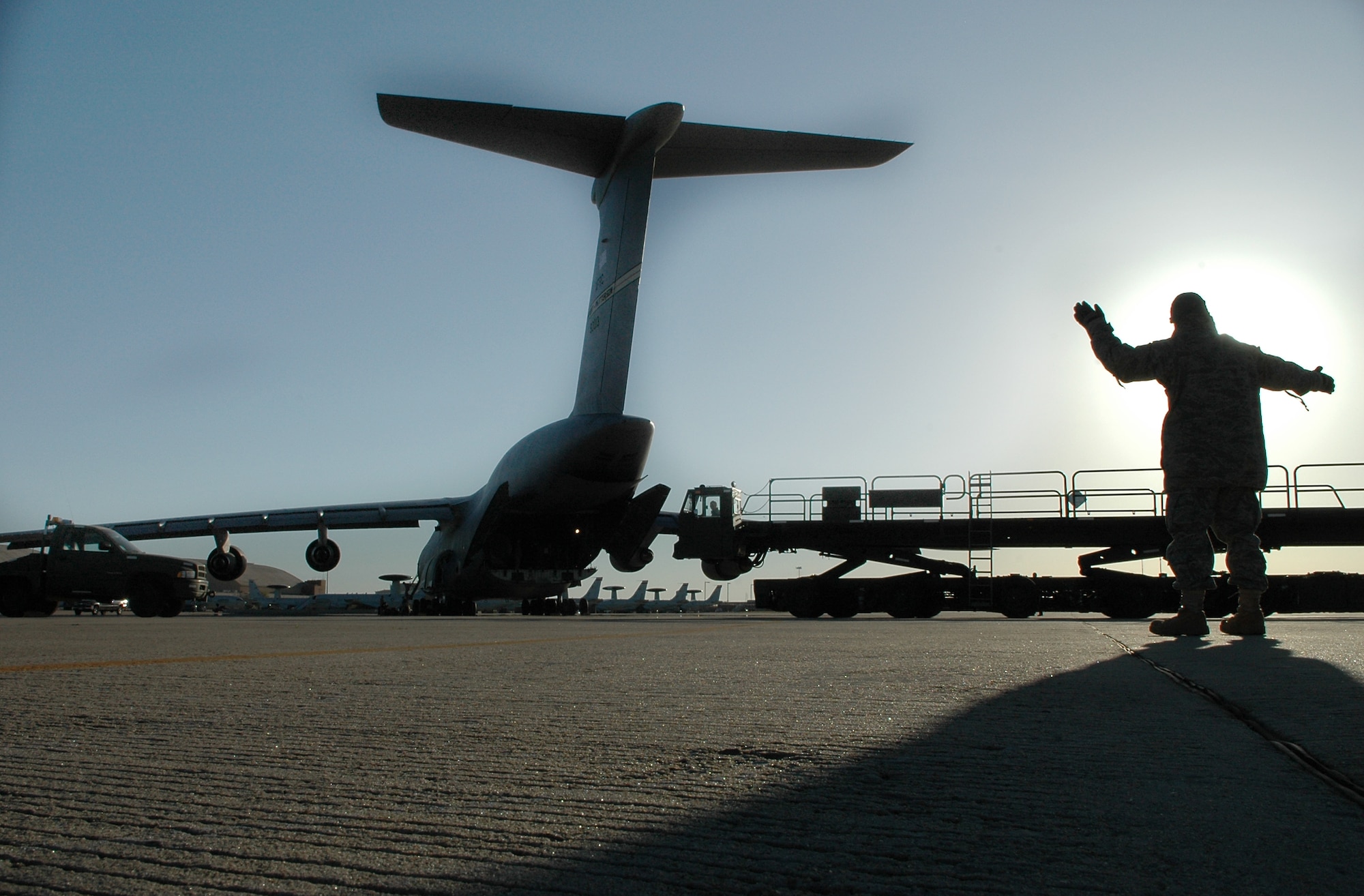 Tech. Sgt. Ledandrick Moore, 72nd Logistics Readiness Squadron, directs the driver of a loader after it delivered pallets for a 552nd Air Control Wing deployment to the cargo bay of a C-5 Globemaster from the 89th Airlift Squadron at Wright Patterson Air Force Base, Ohio. (Air Force photo by Micah Garbarino)