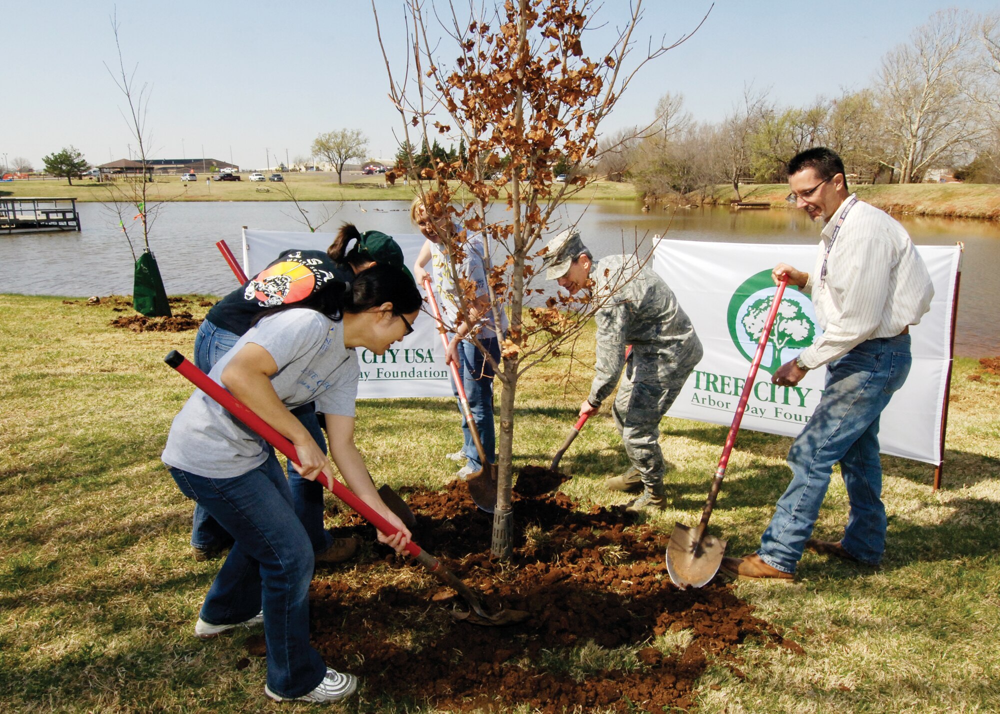 In front of dozens of tree planting volunteers, the official ceremony marking Tinker’s Arbor Day celebration ends with planting a Caddo Maple at the Fam Camp’s Beaver Pond. From left are; Tina Unten, Rose State College student and Tinker Federal Civic Leaders Group; Donna Nolan, military spouse and volunteer; Lisa Will, Rose State College professor and sponsor; Col. Robert LaBrutta, 72nd Air Base Wing and Installation commander; and John Krupovage, 72nd Civil Engineer Directorate Natural Resources manager. (Air Force photo by Margo Wright)