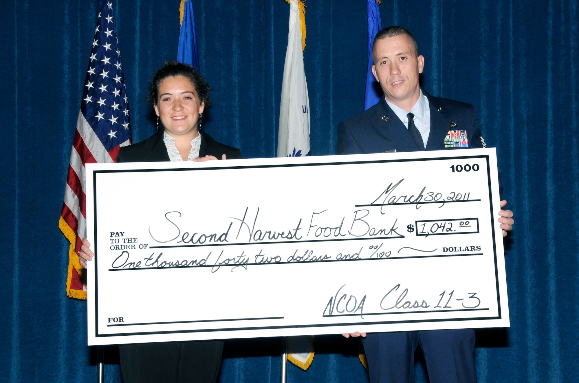 McGHEE TYSON AIR NATIONAL GUARD BASE, Tenn. - NCO Academy student Tech. Sgt. Jory J. Ohmer, right, the NCOIC of refueling maintenance at Charleston AFB, S.C., presents a check for $1,042 to Emily Cavender of the Second Harvest Food Bank of East Tennessee on behalf of Class 11-3 during their graduation ceremony at Wilson Hall here, March 30, 2011. (U.S. Air Force photo by Master Sgt. Kurt Skoglund/Released)