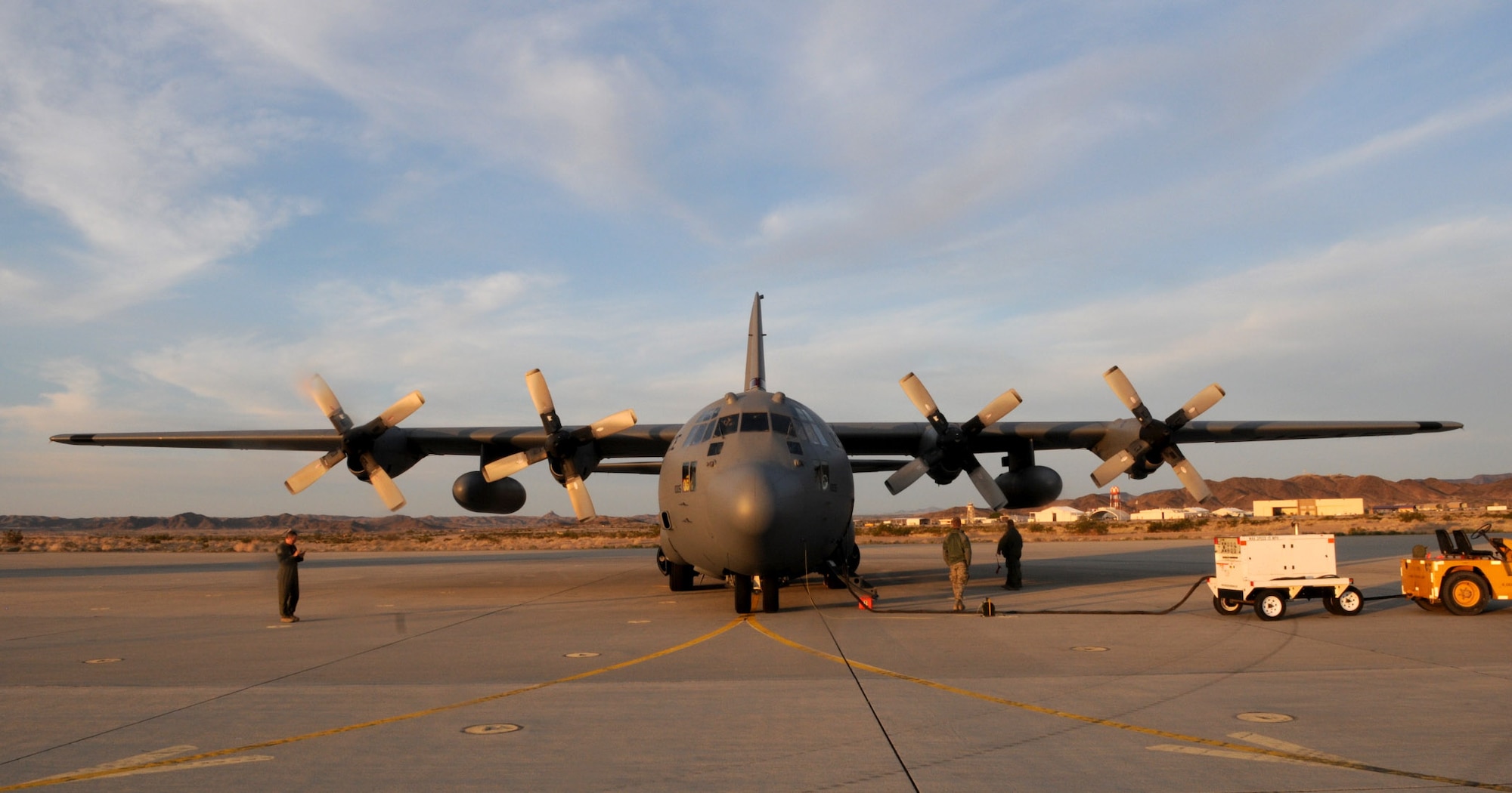Crew members and the aircraft of the 133rd await departure in the early morning sun on Mar. 4, 2011 at Yuma Proving Ground, Yuma, Ariz. During the week of Feb. 28th, 2011 Airmen and the C-130 Hercules of the 133rd Airlift Wing, Minnesota Air National Guard deployed for training to Yuma Proving Ground where they practiced Low-Cost Low-Altitude airdrops. This knowledge and experience will be directly applied during deployment to Afghanistan. The LCLA bundles are more accurate and use expendable parachutes weighing in at 80 to 500 pounds. LCLA is well suited for small units on patrol or in remote outposts where they don't have the equipment or manpower to deal with the larger container delivery system bundles. U.S. Air Force photo by Tech. Sgt. Erik Gudmundson