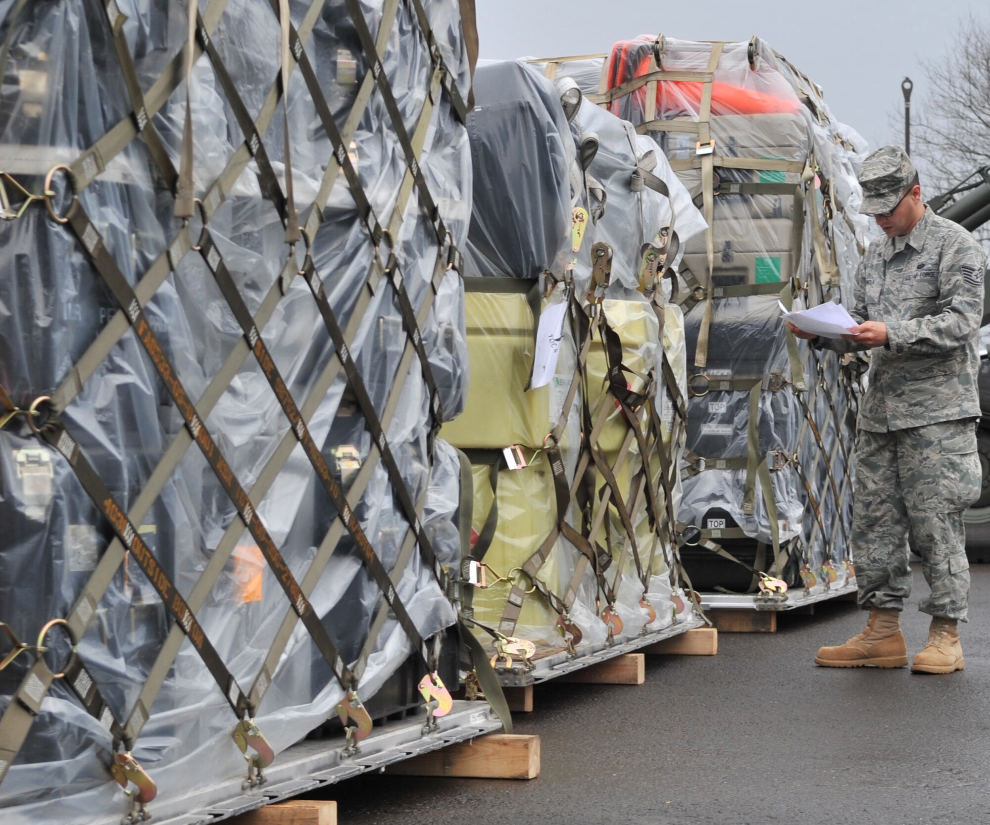 U.S. Air Force Tech. Sgt. Randy Pinola, 1st Combat Communications Squadron increment monitor, checks cargo documents for mission processing in support of Operation Unified Protector, Ramstein Air Base, Germany, April 1, 2011. Unified Protector is a NATO-led operation in Libya to protect civilians and civilian-populated areas under threat of attack. (U.S. Air Force photo by Senior Airman Caleb Pierce)