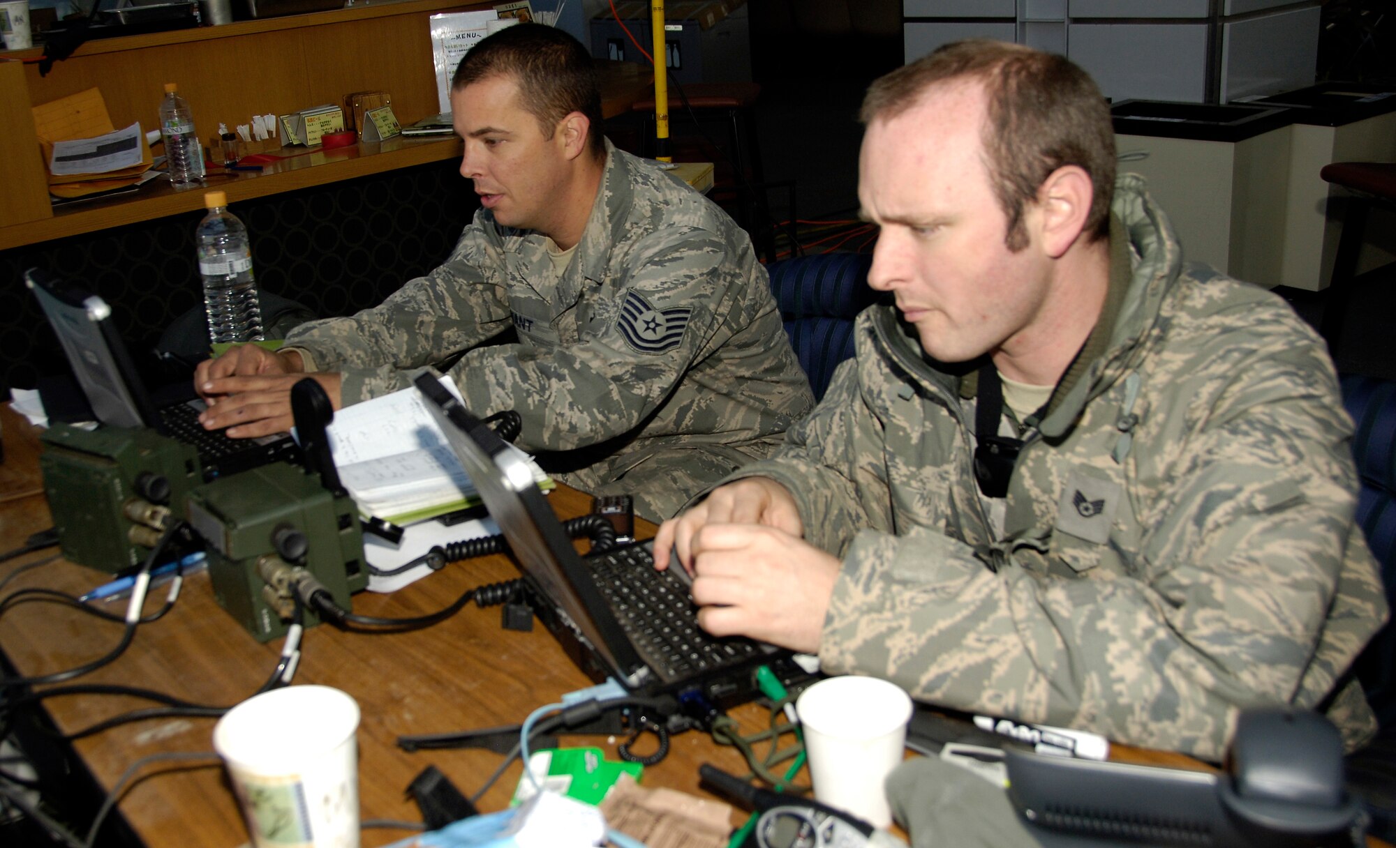 SENDAI, Japan -- Tech Sgt. Denis Bryant (left) and Staff Sgt. Chris Sefton review aircraft landing schedules March 29, 2011. The Airmen forward deployed to Sendai Airport to help the Japanese recover and rebuild in the wake of the March 11 9.0-magnitude earthquake and tsunami. Sergeant Bryant is an air transportation craftsman from Hickam Air Force Base, Hawaii; Sergeant Sefton is a ground radio technician from Kadena Air Base, Japan. (U.S. Air Force Photo/ Staff Sgt. J.G. Buzanowski)