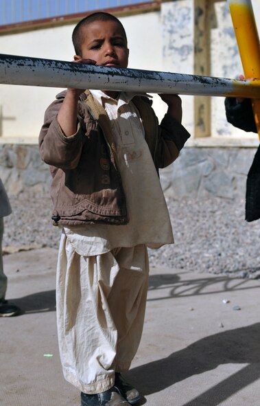 An orphan stands near a swing-set at Herat City Orphanage March 26, 2011. The orphanage houses 105 boys between the ages of 4 and 16. They live in ragged condition with carpet-less concrete floors, broken dining tables and discolored walls. (U.S. Air Force photo/Tech. Sgt. Kevin Wallace)