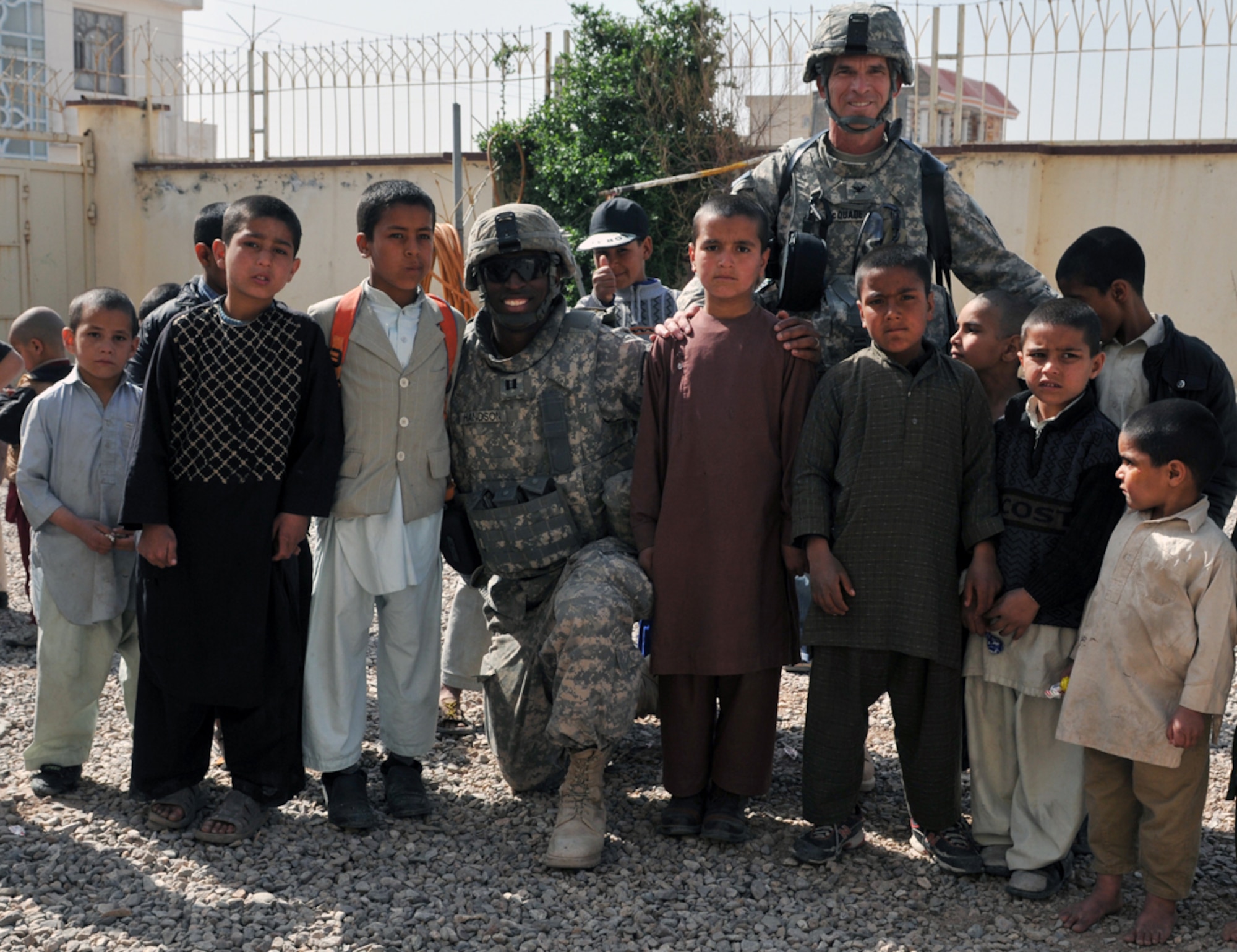 U.S. Army Capt. Tywin Handson, 7th Squadron, 10th Cavalry Regiment, Dragon Troop commander (center) and Army Col. William McQuade, Afghan National Army 207th Corps Legal Advisor, pose with Afghan orphans outside Herat City Orphanage March 26, 2011. The orphanage houses 105 boys between the ages of 4 and 16. They live in ragged condition with carpet-less concrete floors, broken dining tables and discoloured walls. (U.S. Air Force photo/Tech. Sgt. Kevin Wallace)
