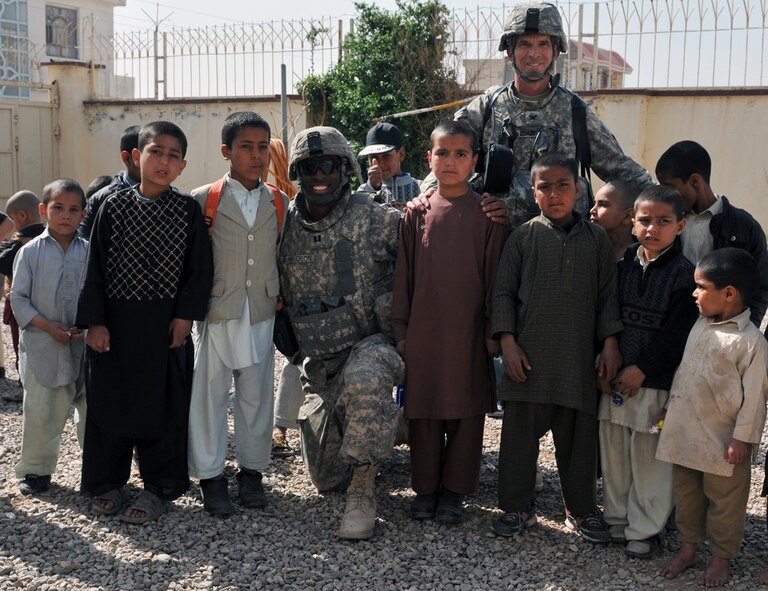U.S. Army Capt. Tywin Handson, 7th Squadron, 10th Cavalry Regiment, Dragon Troop commander (center) and Army Col. William McQuade, Afghan National Army 207th Corps Legal Advisor, pose with Afghan orphans outside Herat City Orphanage March 26, 2011. The orphanage houses 105 boys between the ages of 4 and 16. They live in ragged condition with carpet-less concrete floors, broken dining tables and discoloured walls. (U.S. Air Force photo/Tech. Sgt. Kevin Wallace)