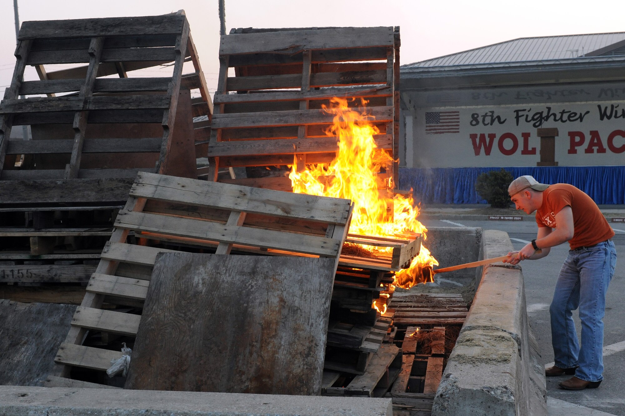 KUNSAN AIR BASE, Republic of Korea -- Kunsan's newest Airman, Airman First Class Gabriel Reyna, 8th Civil Engineer Squadron fire protection, ignites a bonfire with a torch during a pep rally March 31 for the start of the base Pacific Air Force Operational Readiness Inspection. (U.S. Air Force photo/Tech. Sgt. Jonathan Pomeroy)
