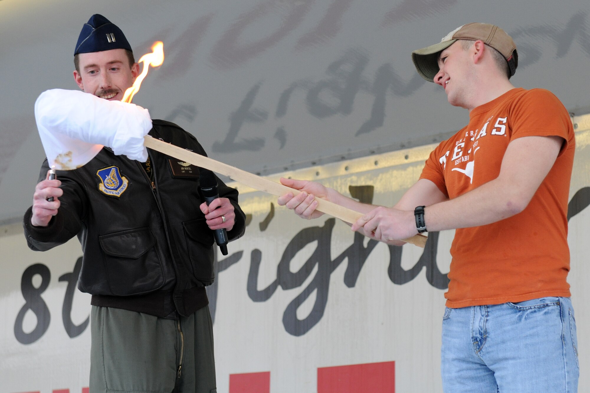 KUNSAN AIR BASE, Republic of Korea --  Capt. Jon Wentzel, 8th Operations Group, lights a torch on fire so Kunsan's newest Airman, Airman First Class Gabriel Reyna, 8th Civil Engineer Squadron fire protection, can ignite a bonfire during a pep rally March 31 for the start of the base Pacific Air Force Operational Readiness Inspection. (U.S. Air Force photo/Tech. Sgt. Jonathan Pomeroy)
